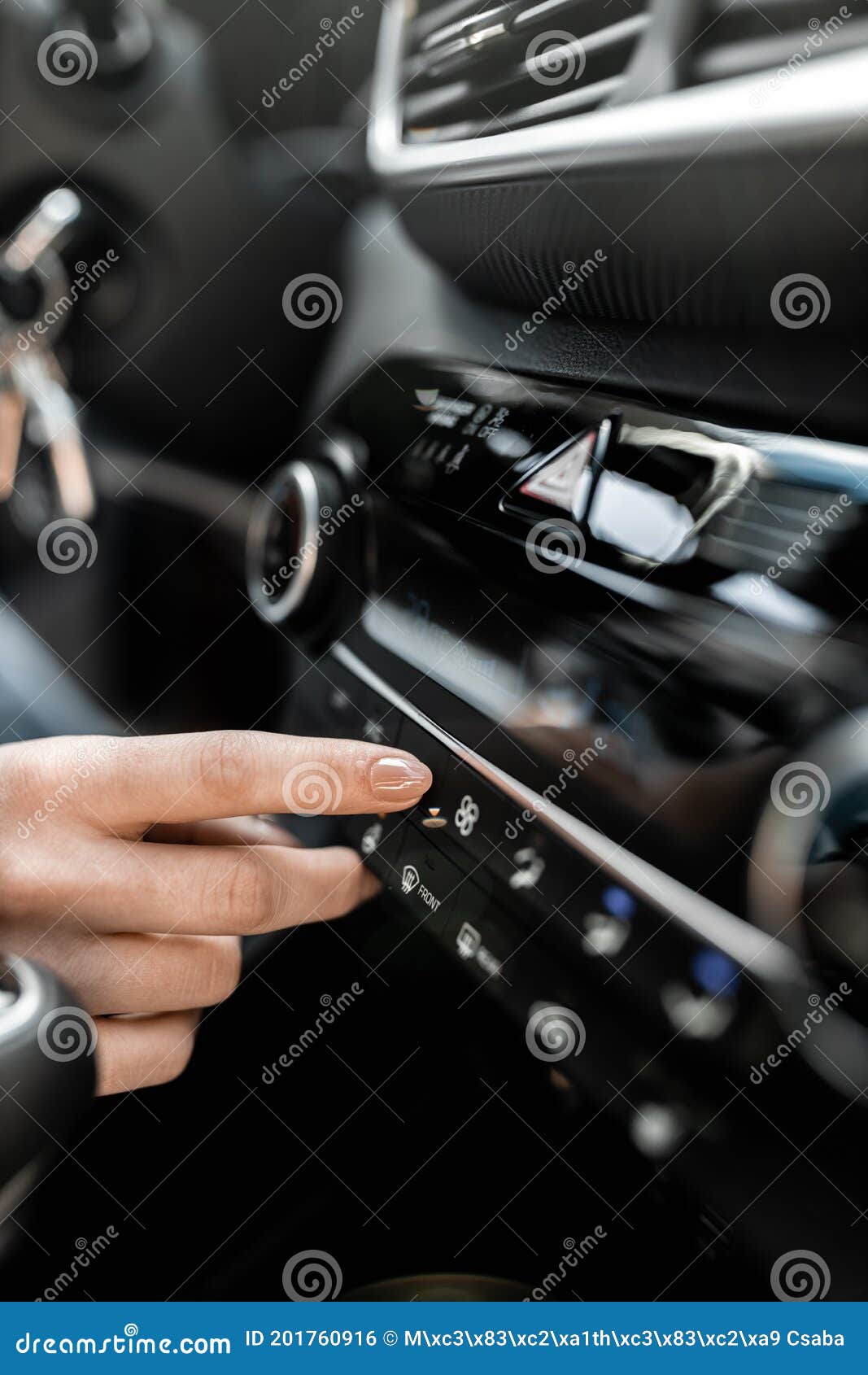 interior view of a modern new car. woman`s hand and climatronic or air conditioner system concept.