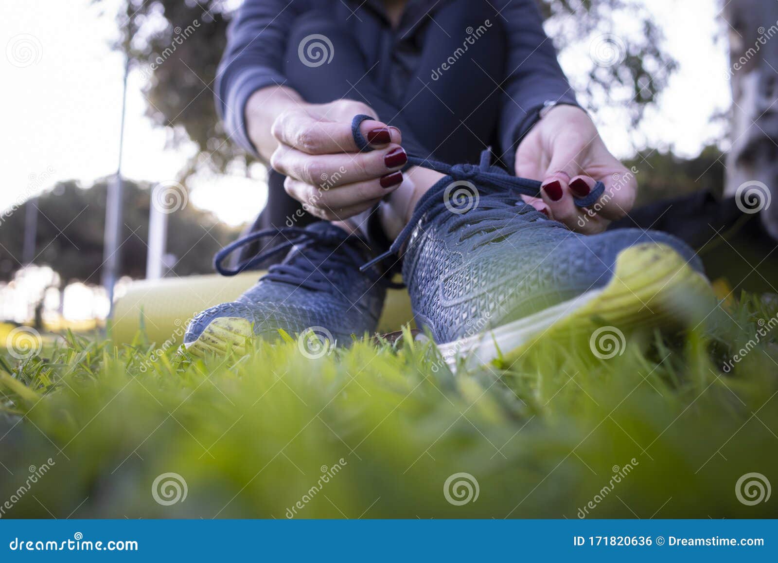 young woman cordoning her running shoes off for a run sesion outdoors in the park