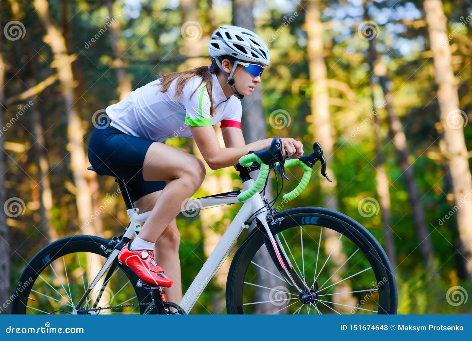 Young Woman Cyclist Riding Road Bicycle On The Free Road In The Forest