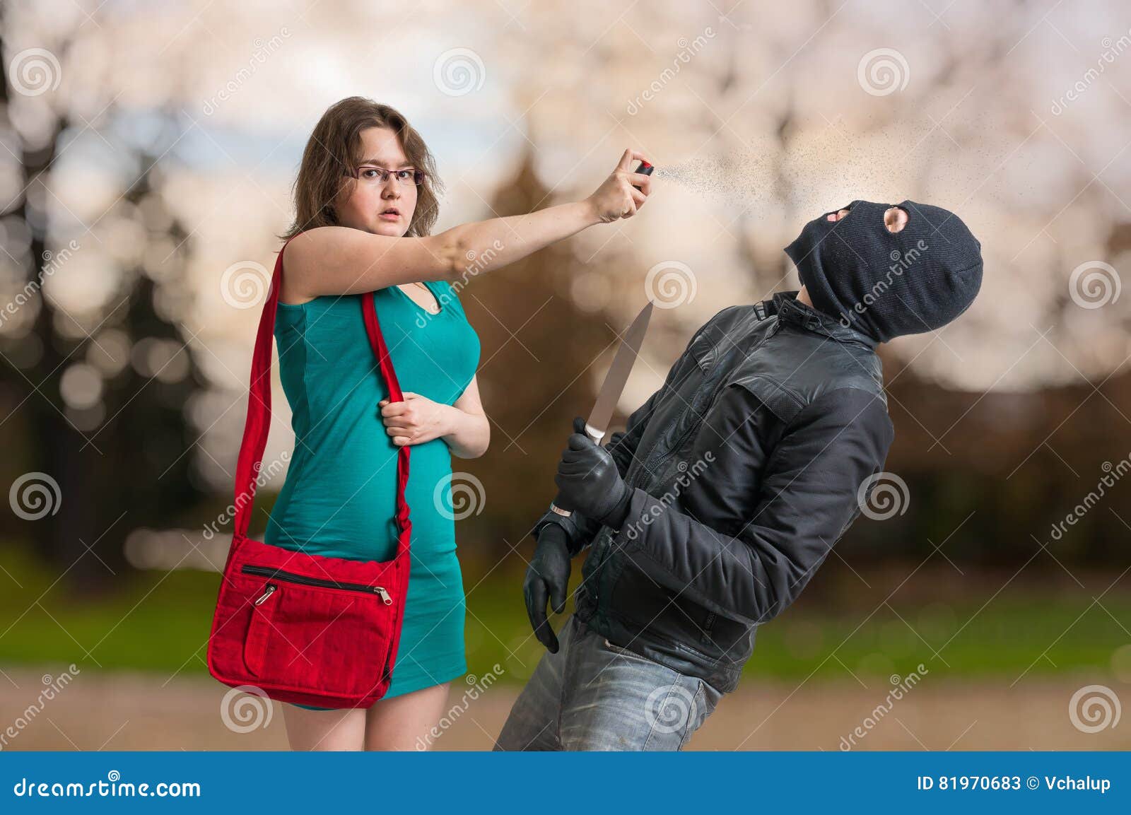young woman is defending with pepper spray against armed thief.
