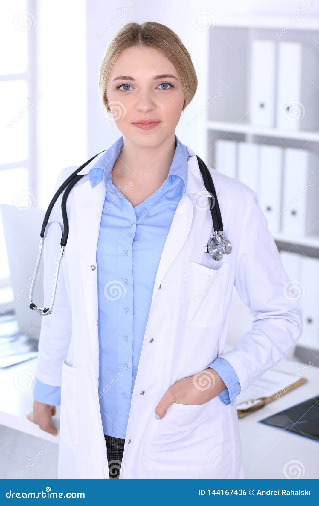 Young Woman Doctor at Work in Hospital Looking at Camera. Blue Colored ...