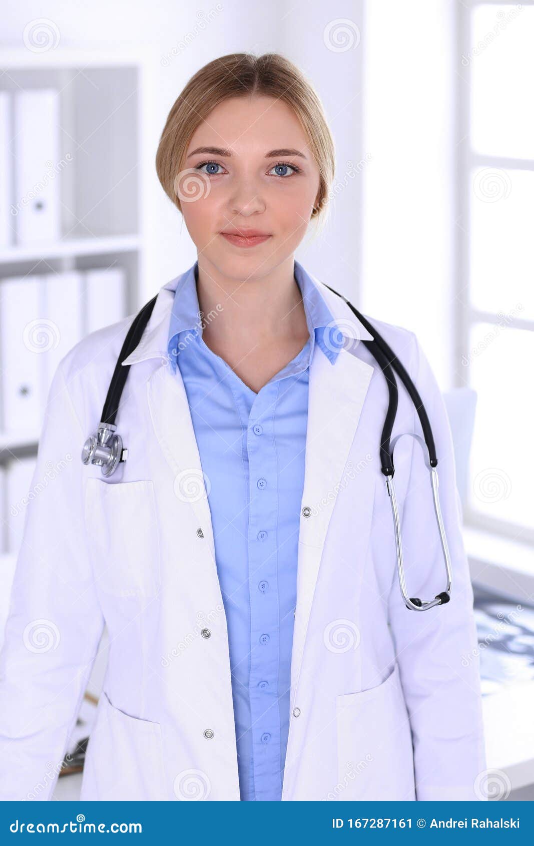 Young Woman Doctor at Work in Hospital Looking at Camera. Blue Colored ...