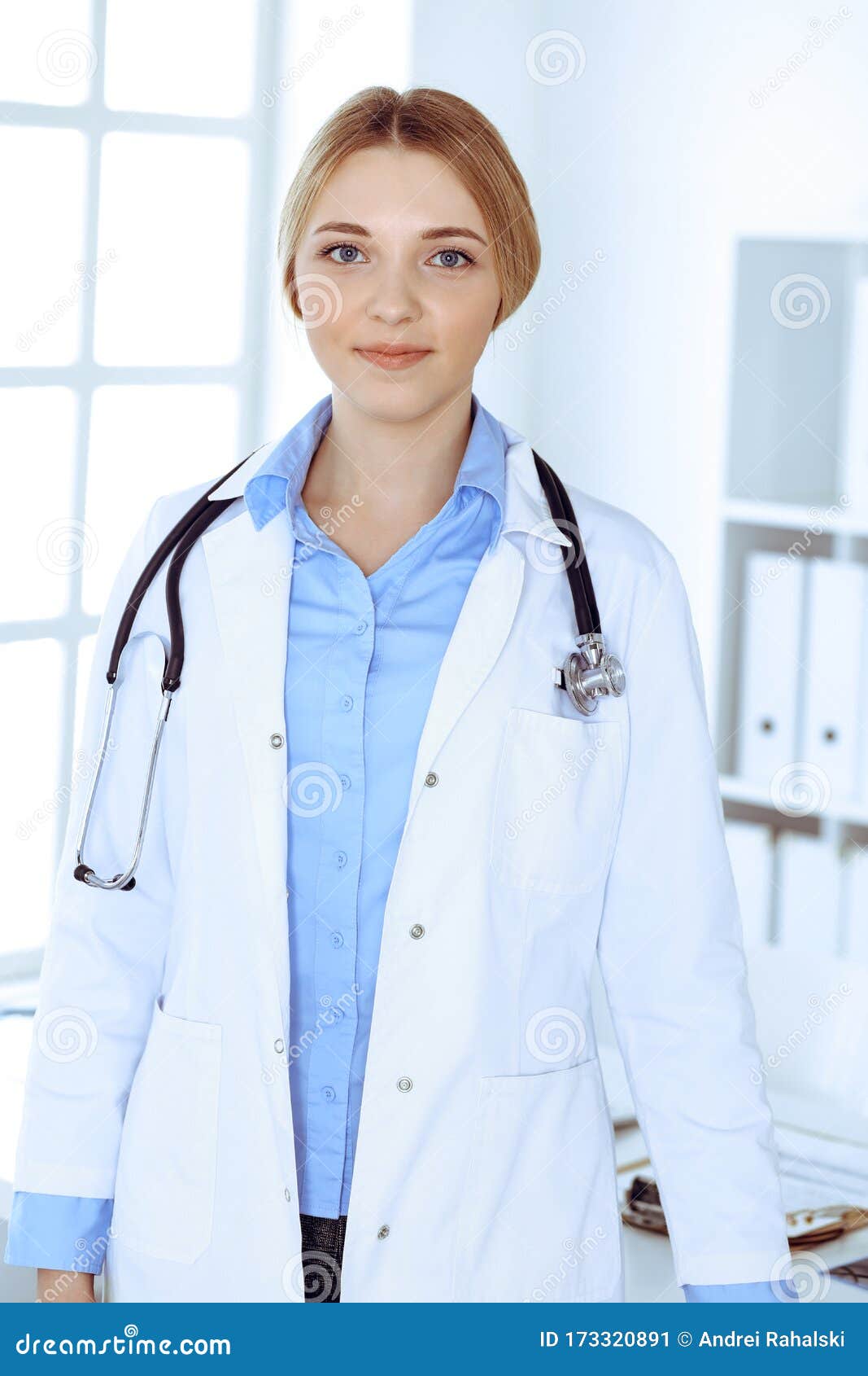 Young Woman Doctor at Work in Hospital Looking at Camera. Blue Colored ...