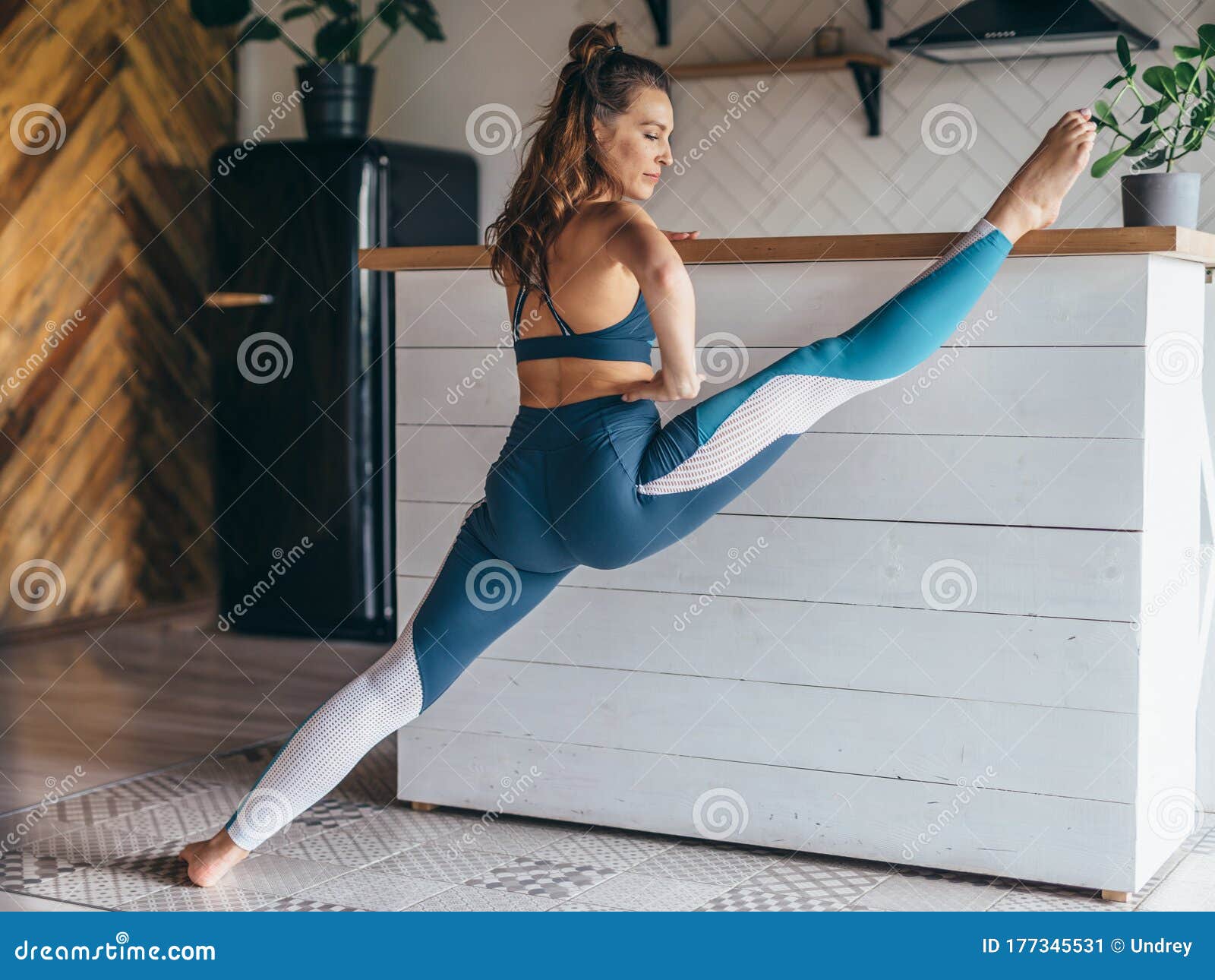 Young Beautiful Sporty Girl Doing Legs Up Exercise 