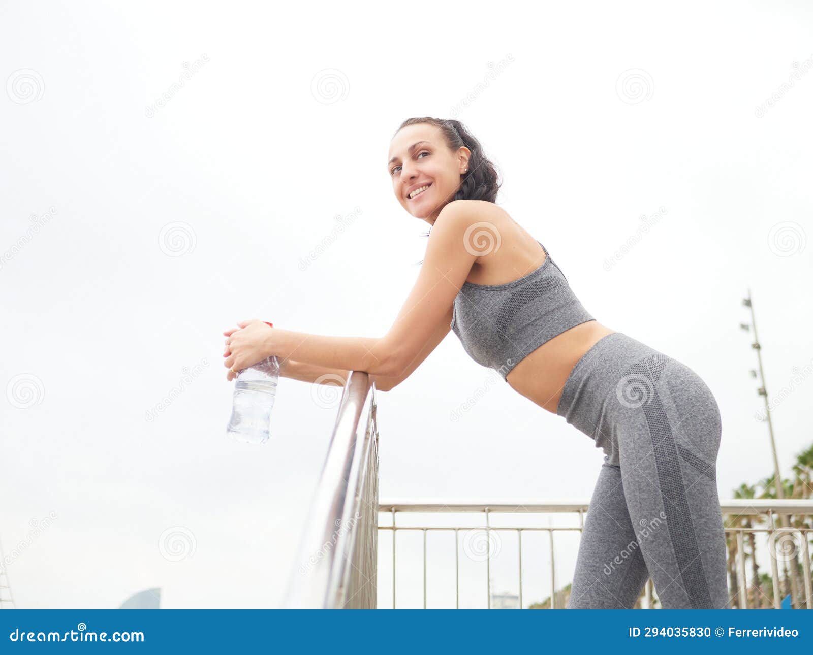 young woman doing stretching at playa de la barceloneta - barcelona spain.