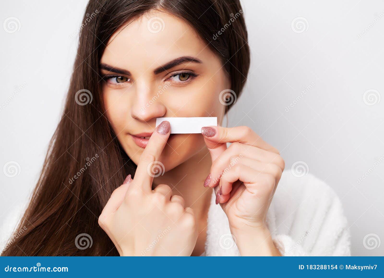 Young Woman Doing Waxing in the Area Above the Eyebrows Stock Photo