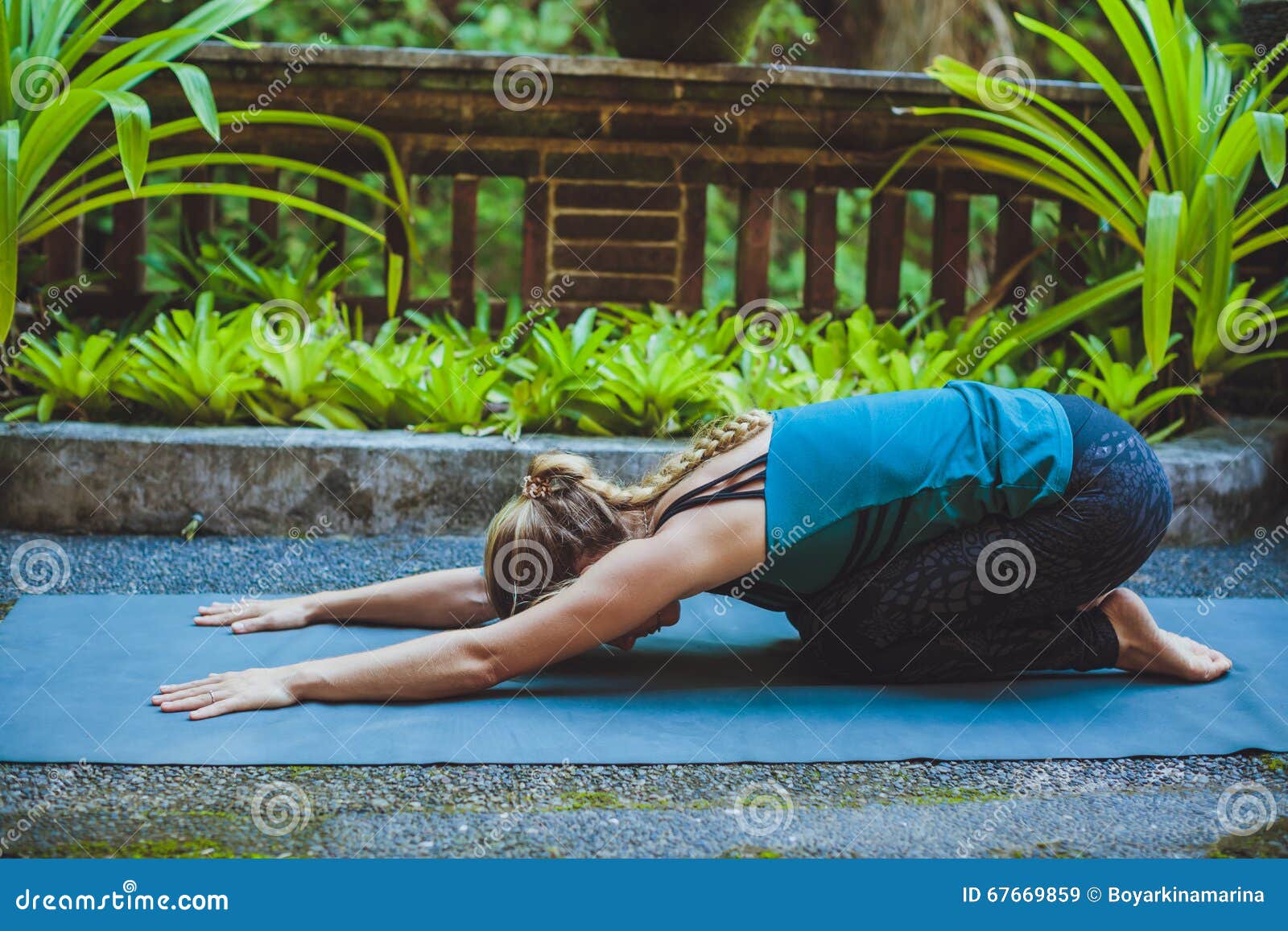 young woman doing yoga outside in natural environment
