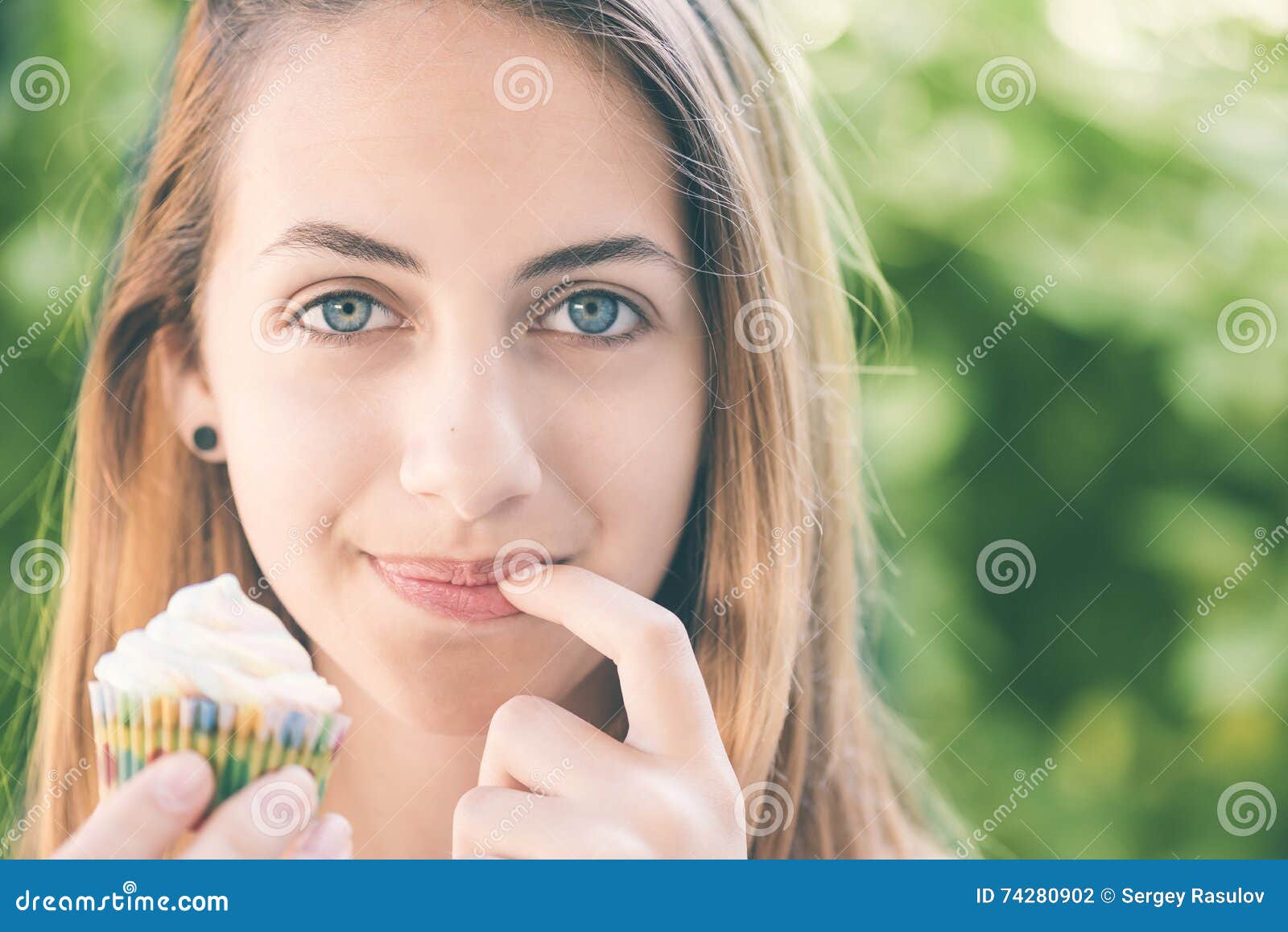 Young Woman Eating Cupcake. Stock Photo Image of finger, person 74280902