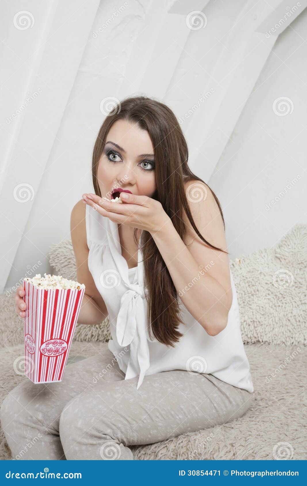 Young Woman Eating Popcorn while Sitting on Bed Stock Image Image of