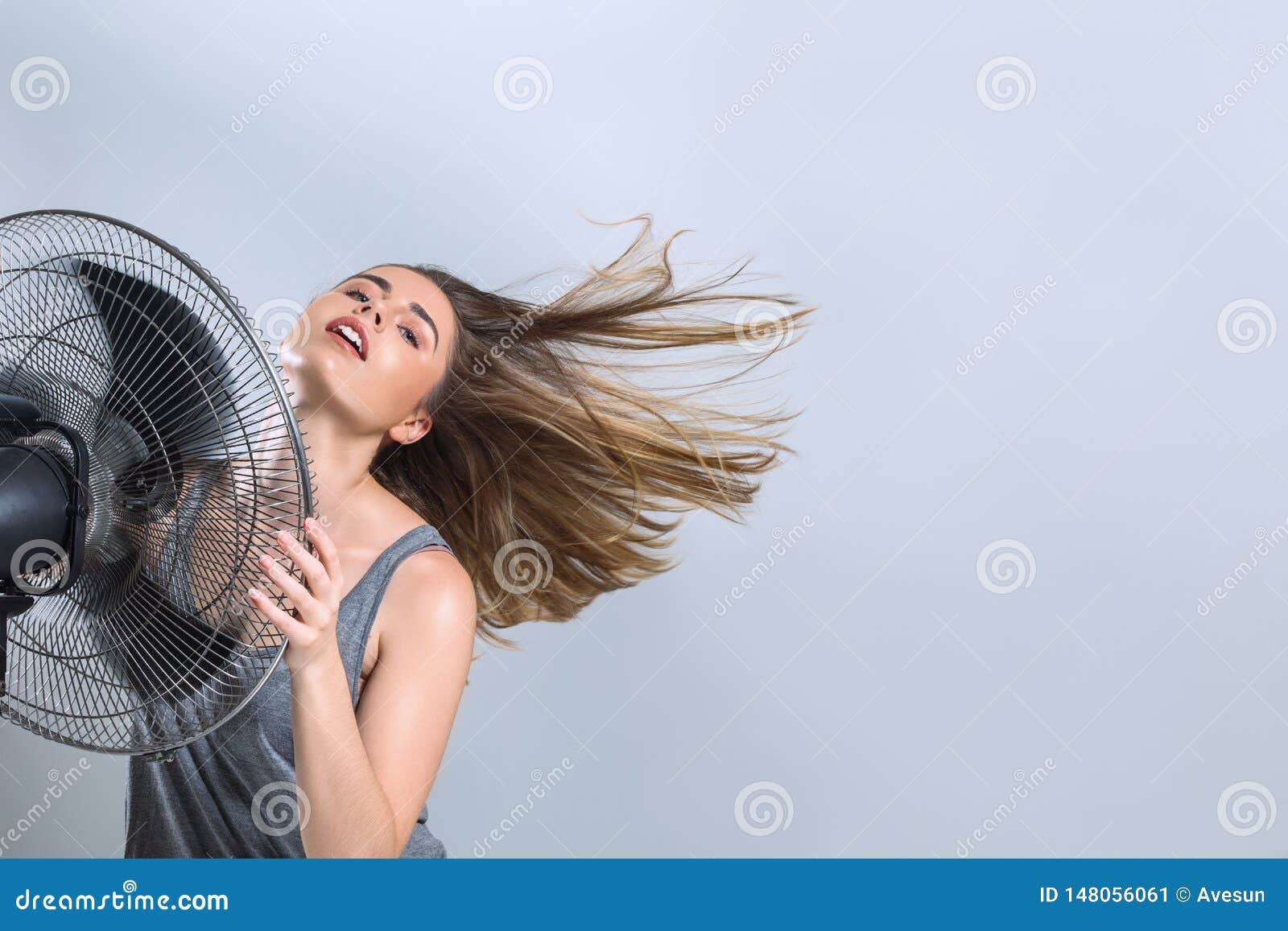 young-woman-enjoying-cool-wind-electric-fan-air-hot-summer-season-heat-wave-148056061.jpg