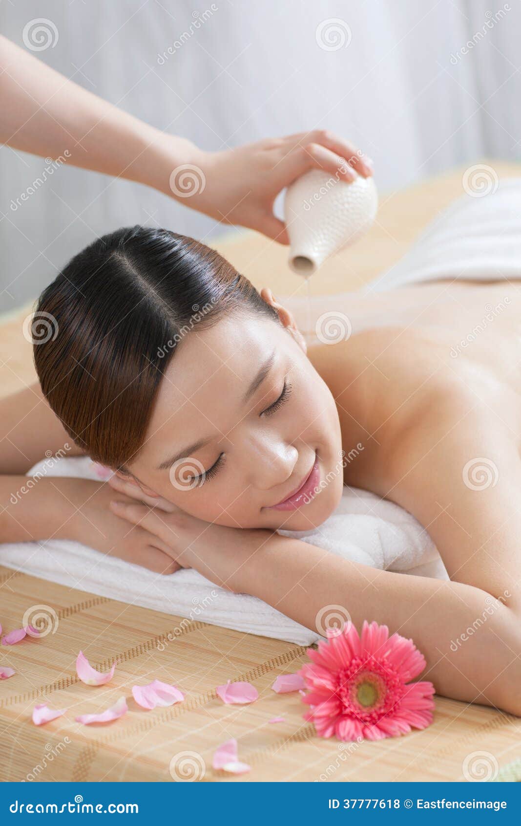 A young woman enjoying massage. A young women enjoying massage at spa salon, indoors.