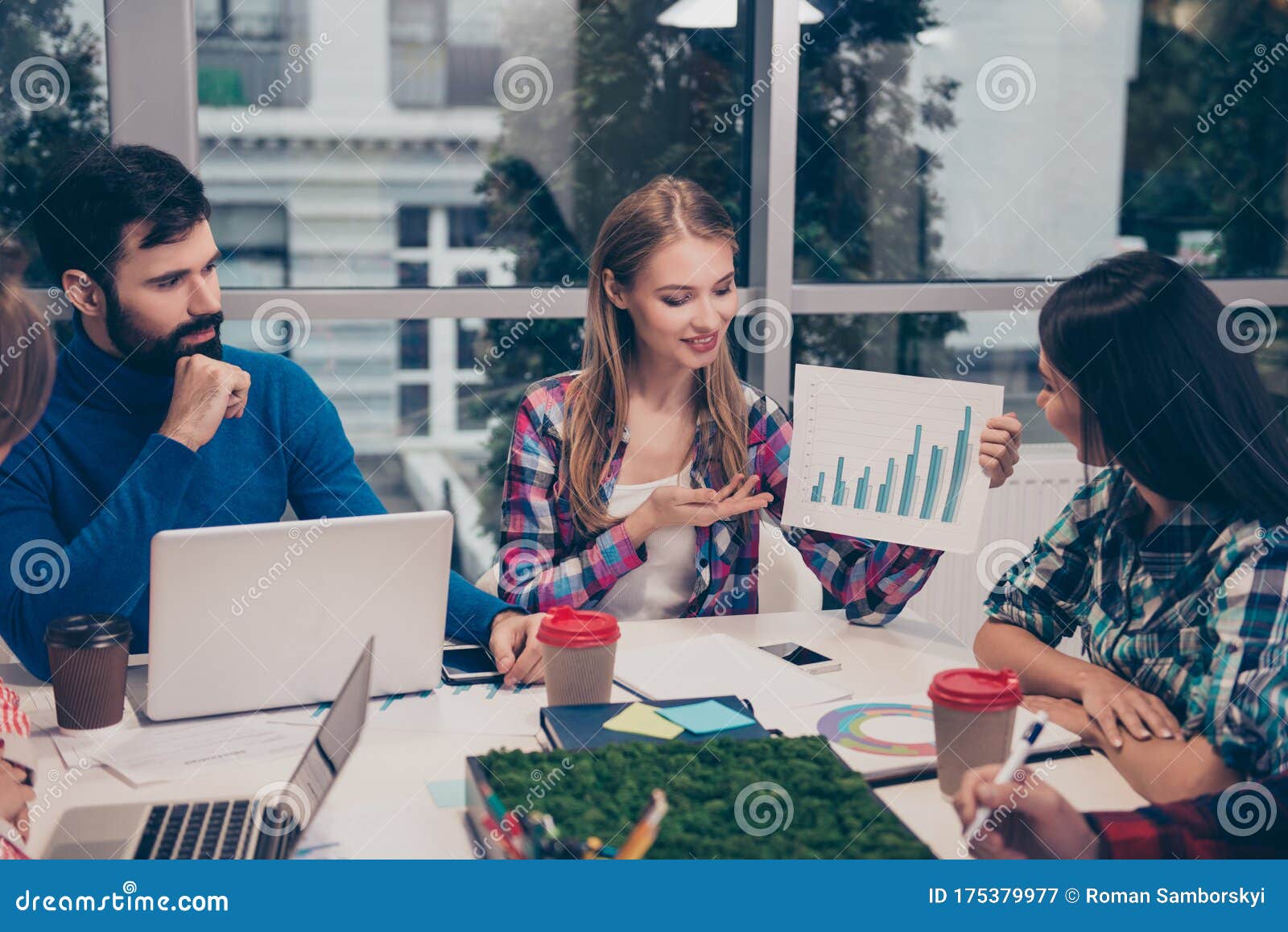 young woman explaining diagrama of financial growh on meeting sitting at desktop