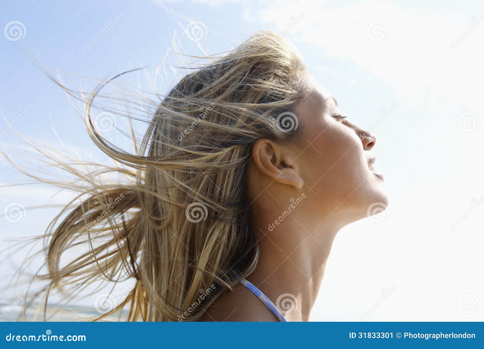 young woman with eyes closed enjoying sunlight