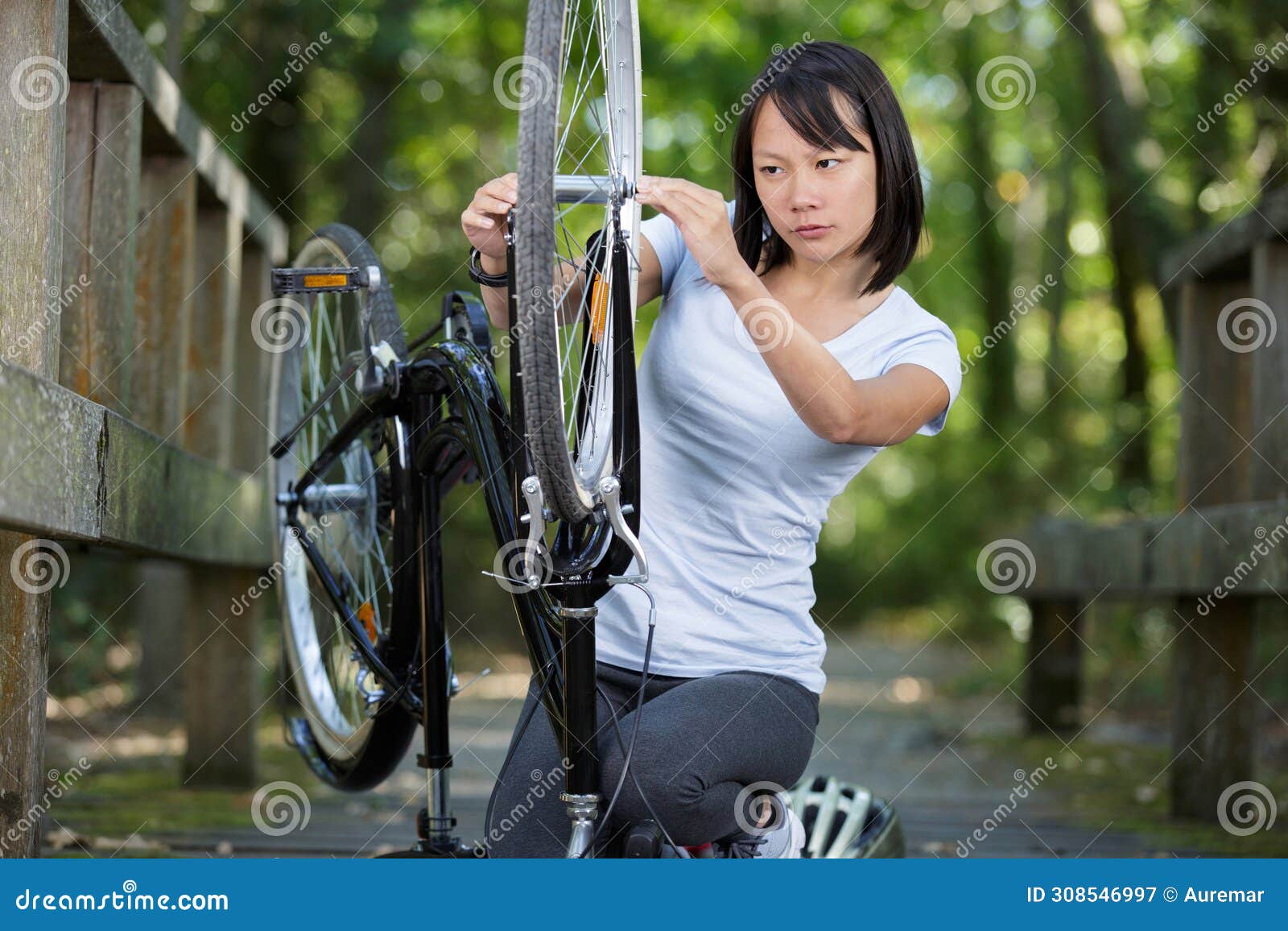 young woman fixing bike outdoors. young woman is fixing her bike outdoors