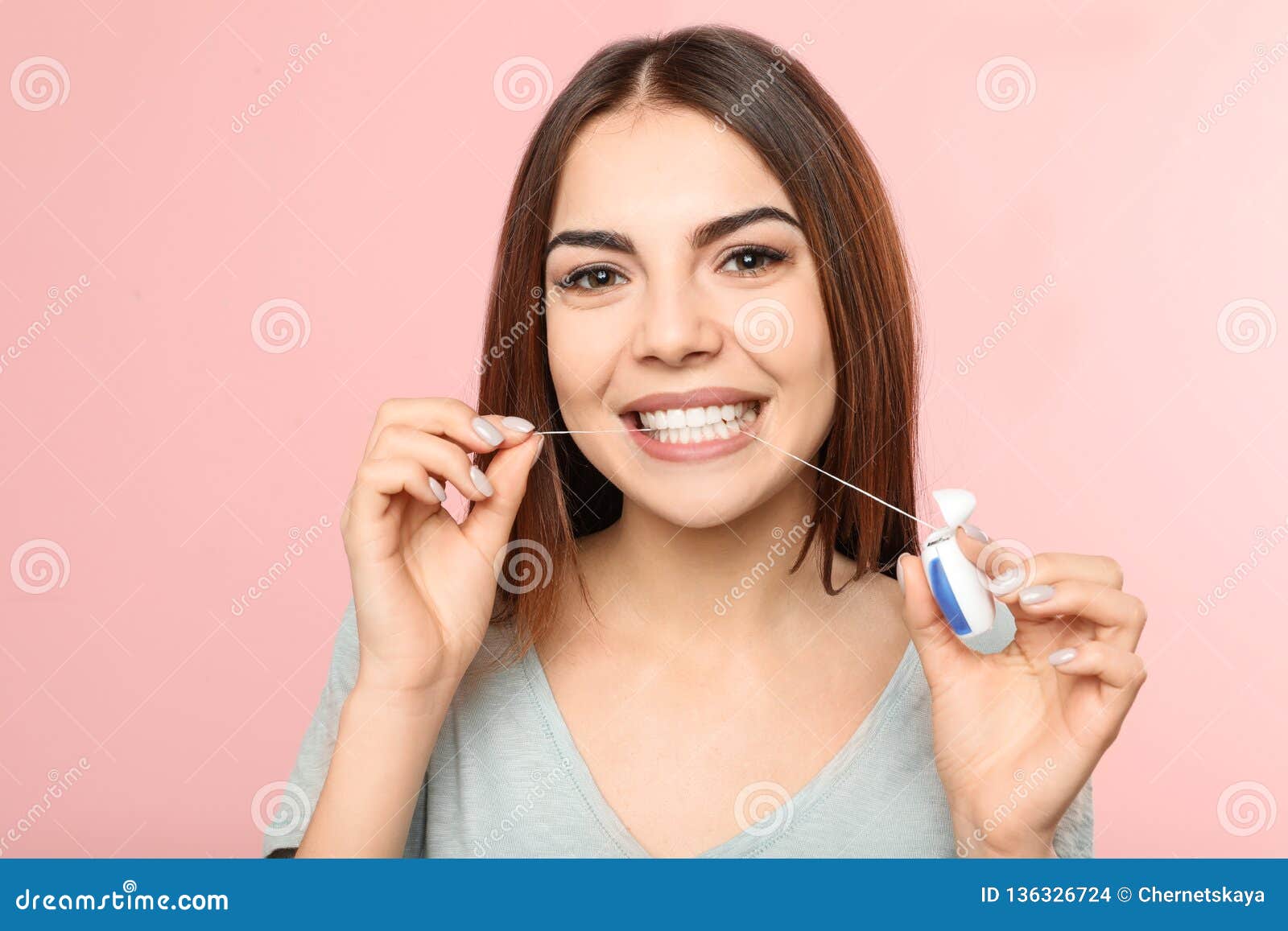 young woman flossing teeth