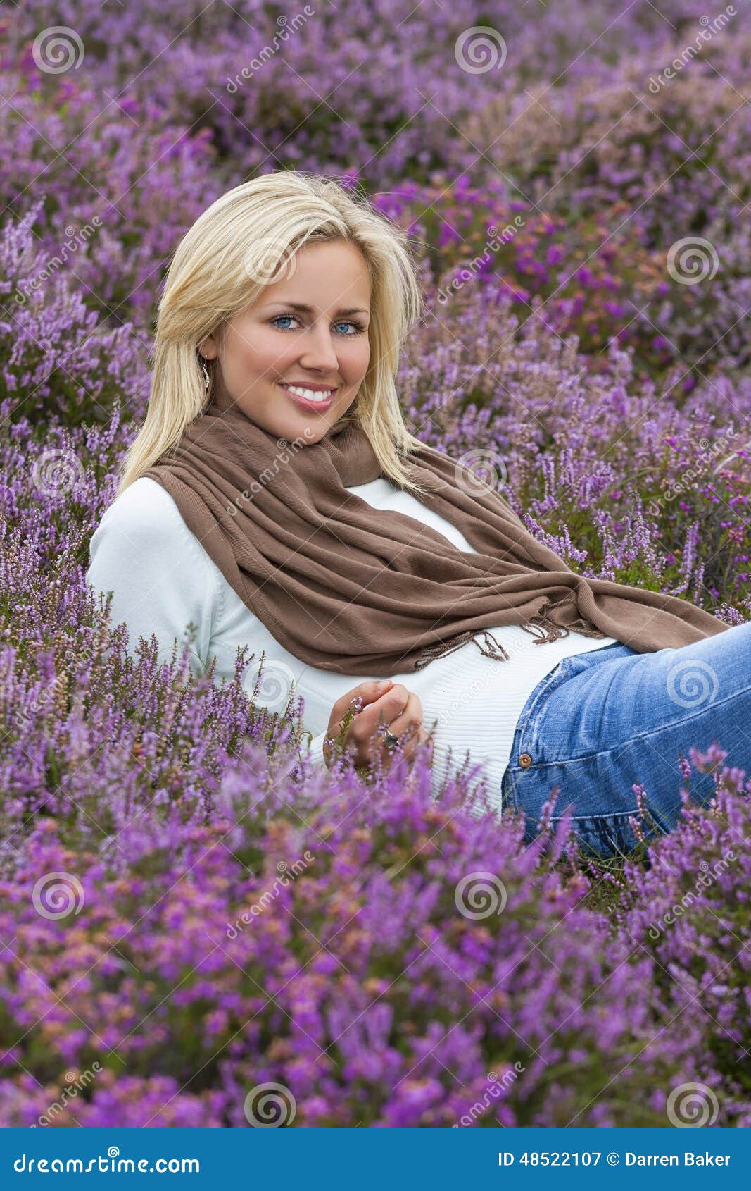 Young Woman Girl in Field of Purple Heather Flowers. A naturally beautiful young blond woman in a field of purple heather flowers