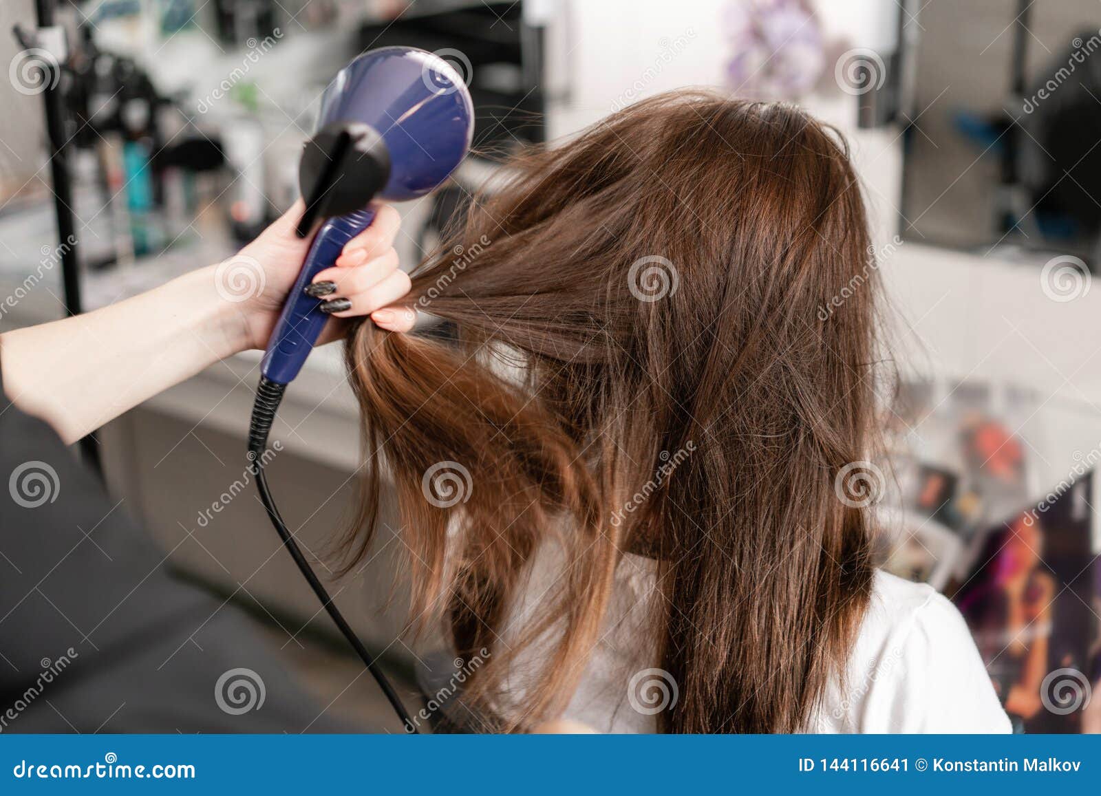 Young Woman And Hairdresser With Fan Making Hot Styling At Hair