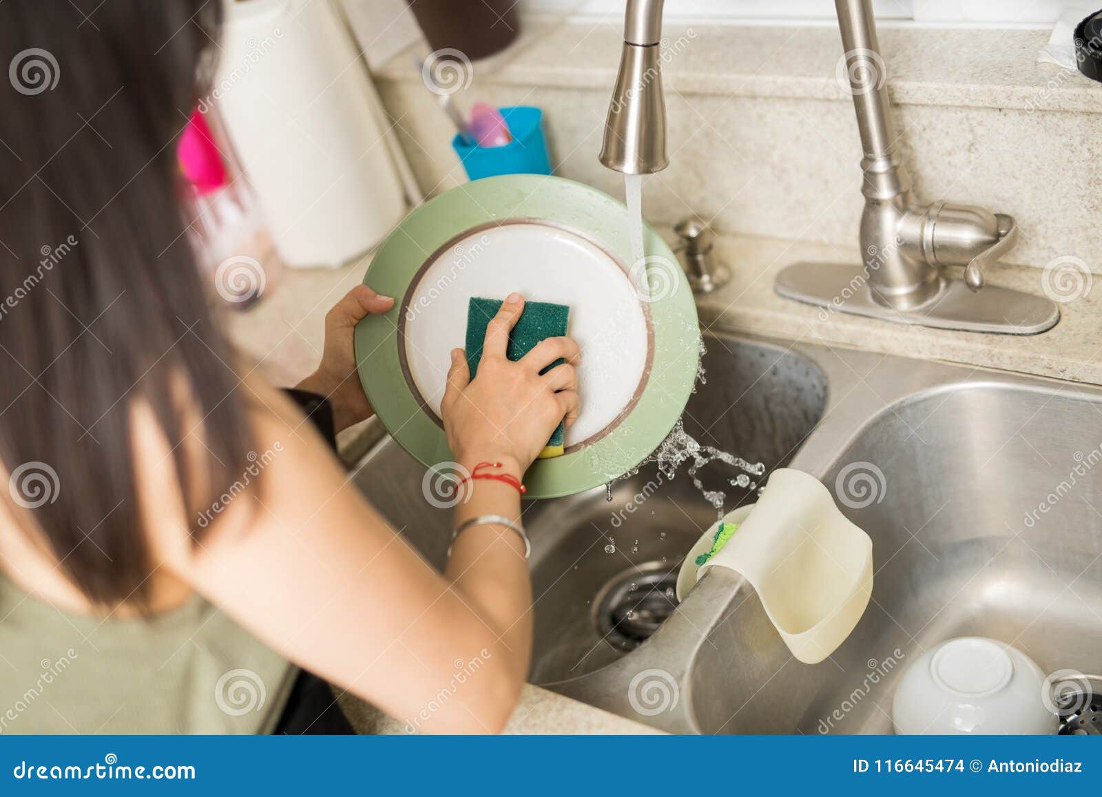 Woman Hand Washing Dishes Over The Sink In The Kitchen Stock