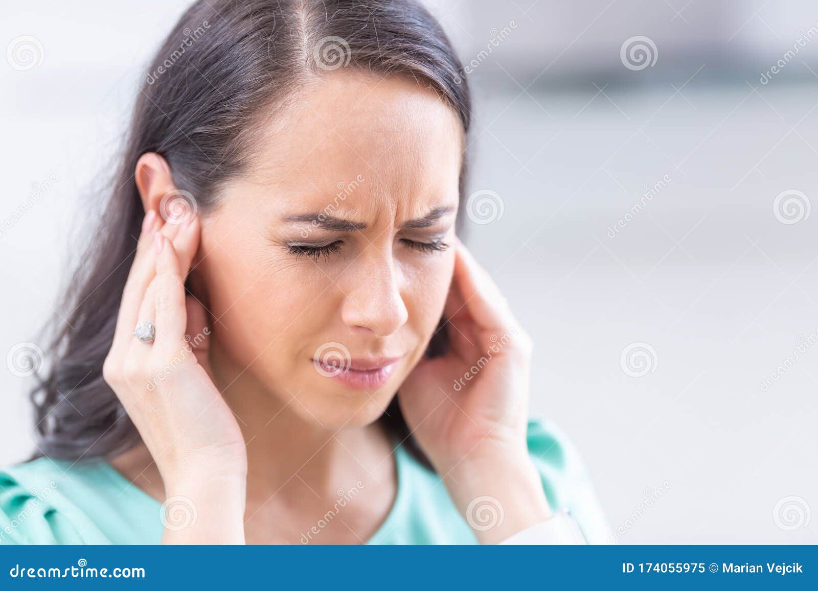 young woman have headache migraine stress or tinnitus - noise whistling in her ears