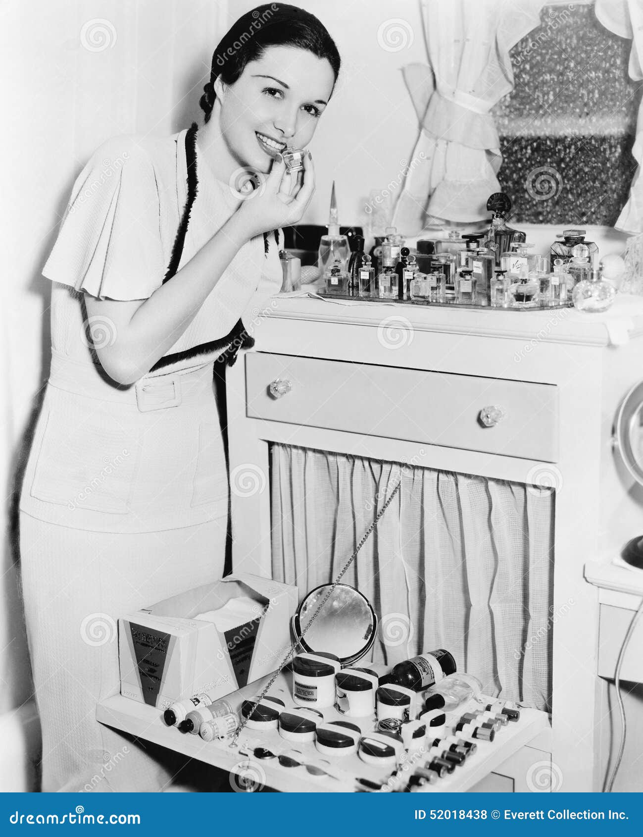 young woman at her vanity applying lipstick