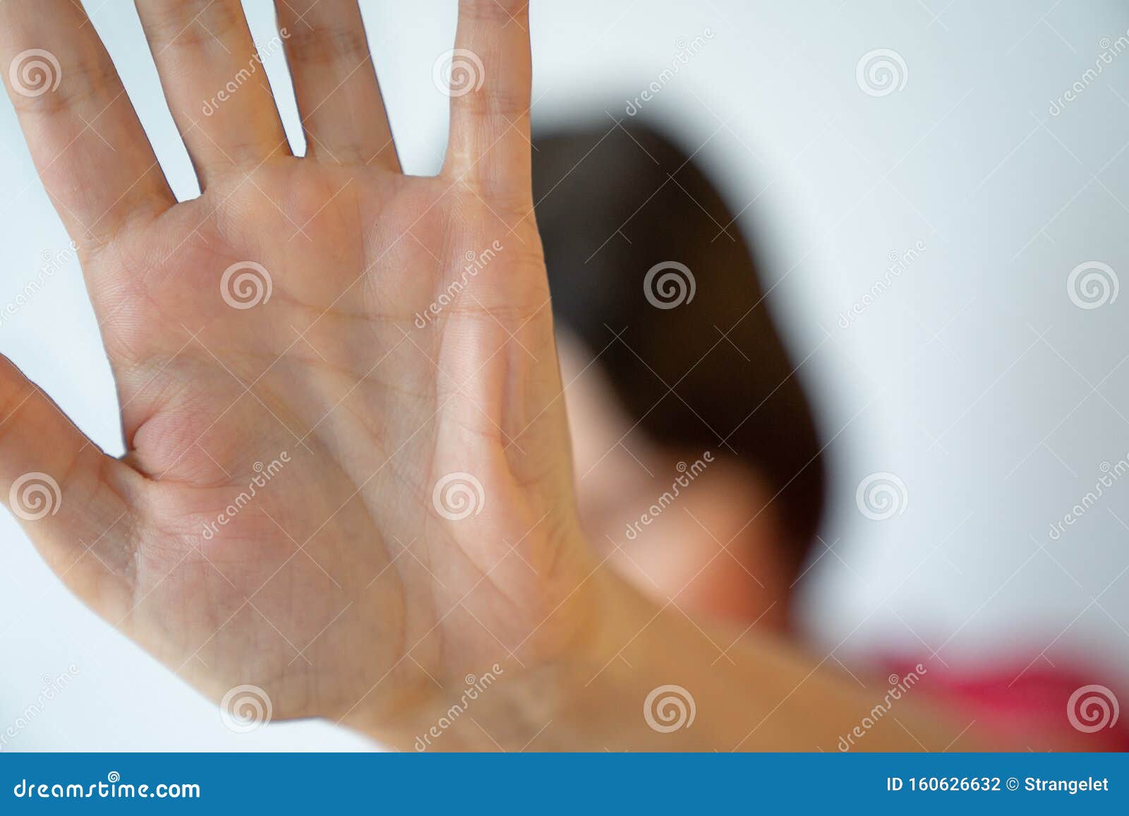 young woman is hiding face with hand, restriction gesture, privacy, anonymity concept