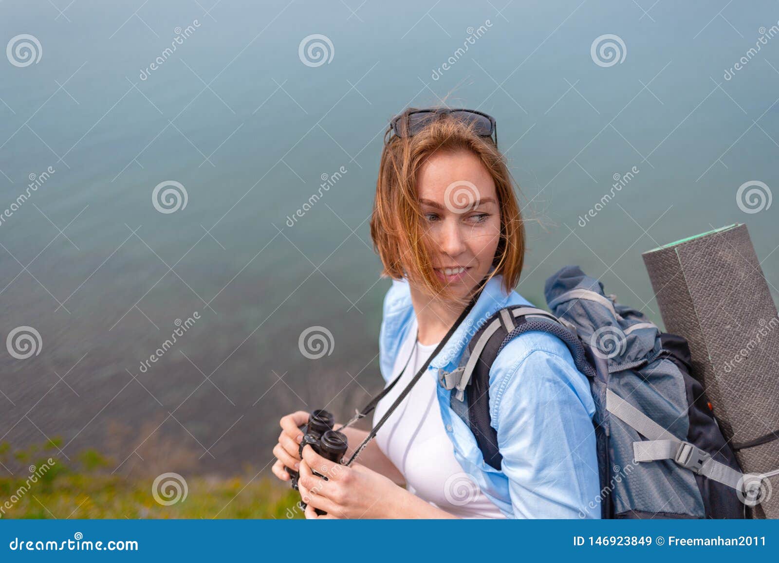 A Young Woman Holding Binoculars and Posing for the Camera. Concept of ...