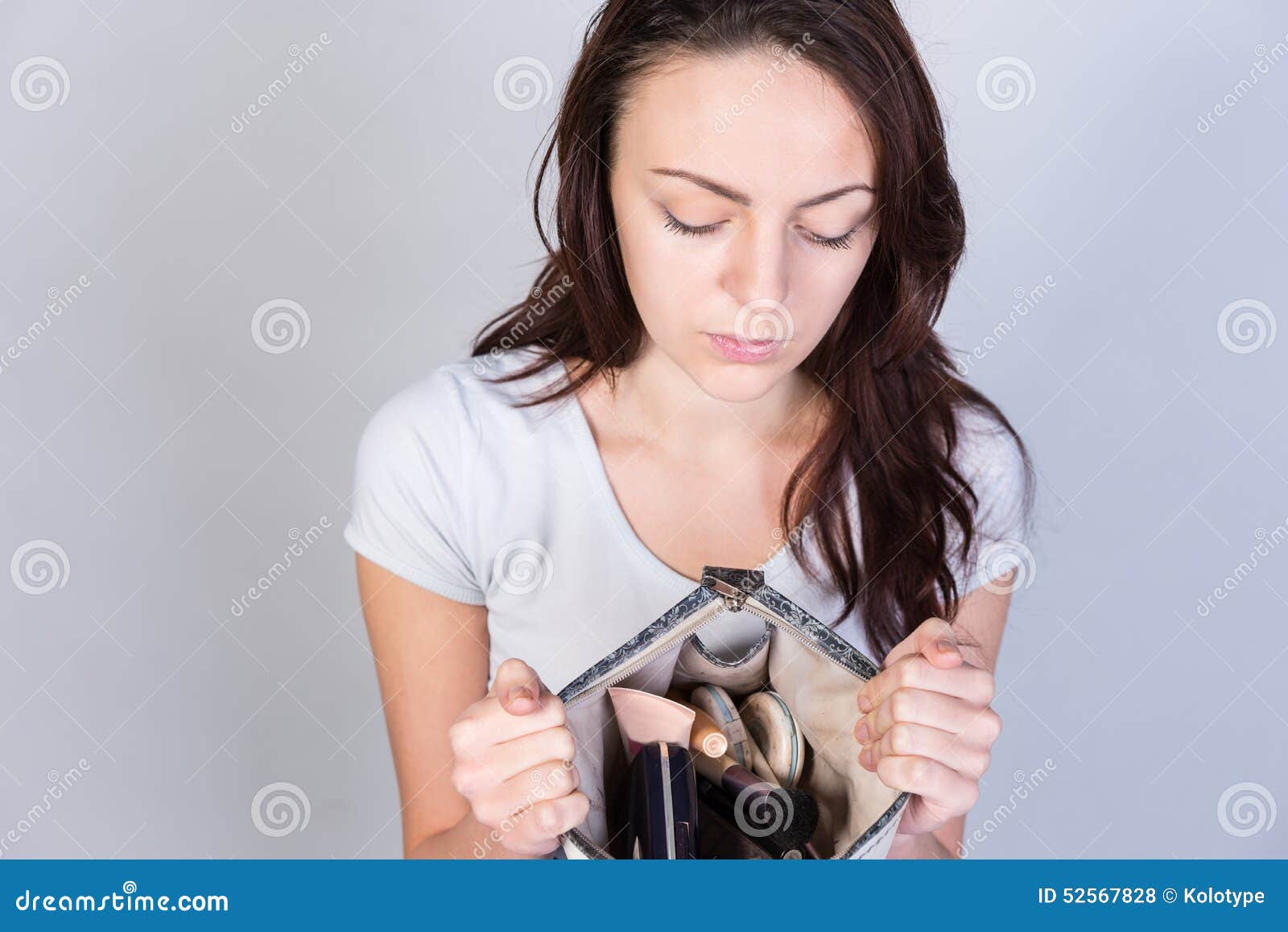 A woman sitting on the ground holding a purse photo – Free Woman
