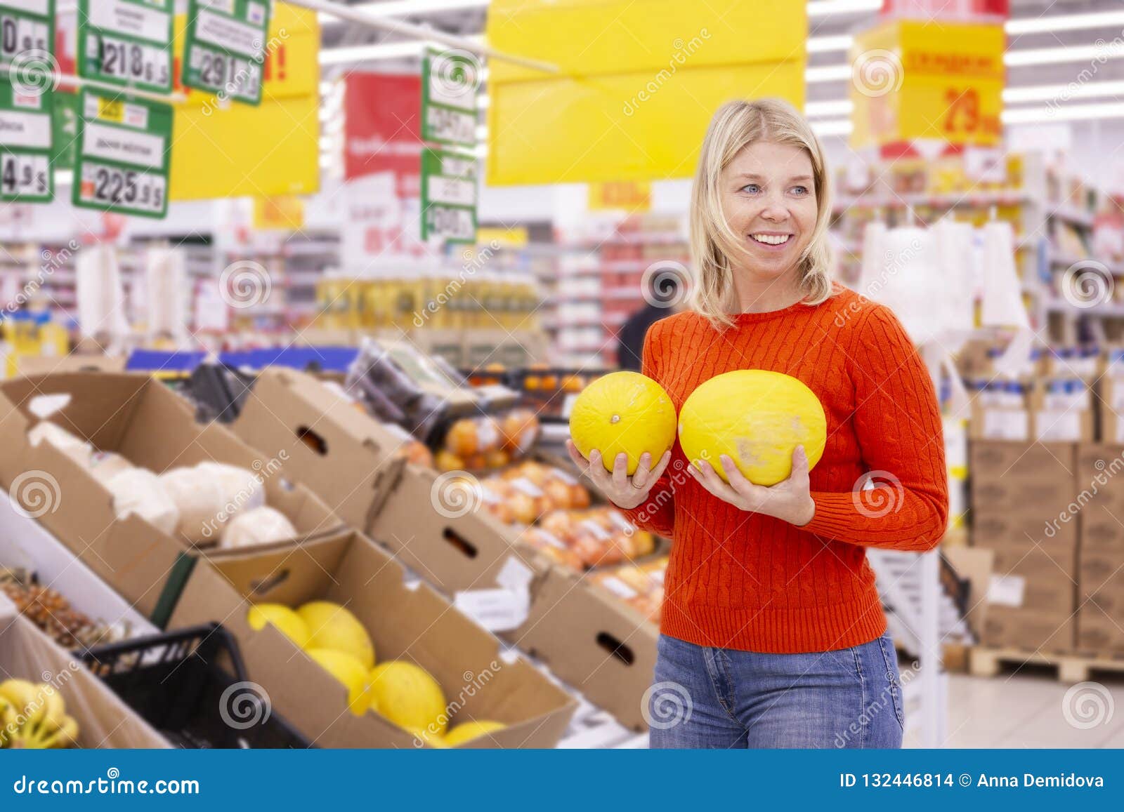 Young woman with juicy melons in the supermarket