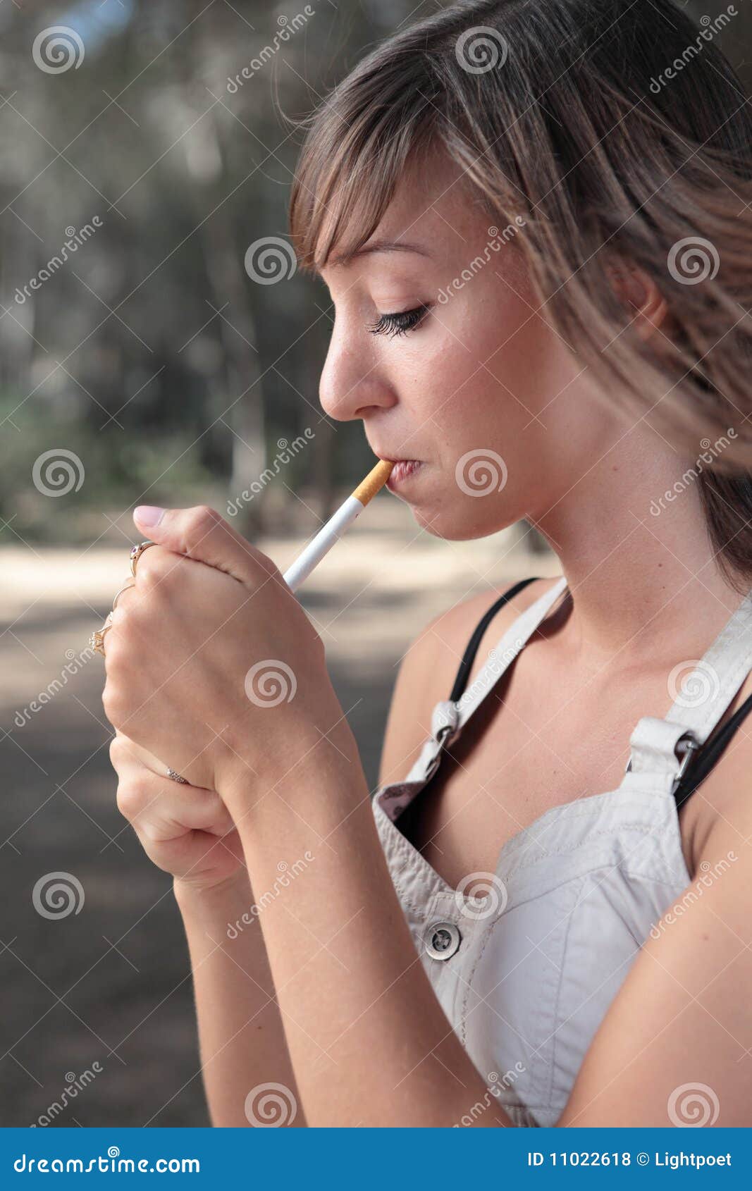 Young Woman Lighting A Cigarette Outdoors Royalty Free Stock Photos