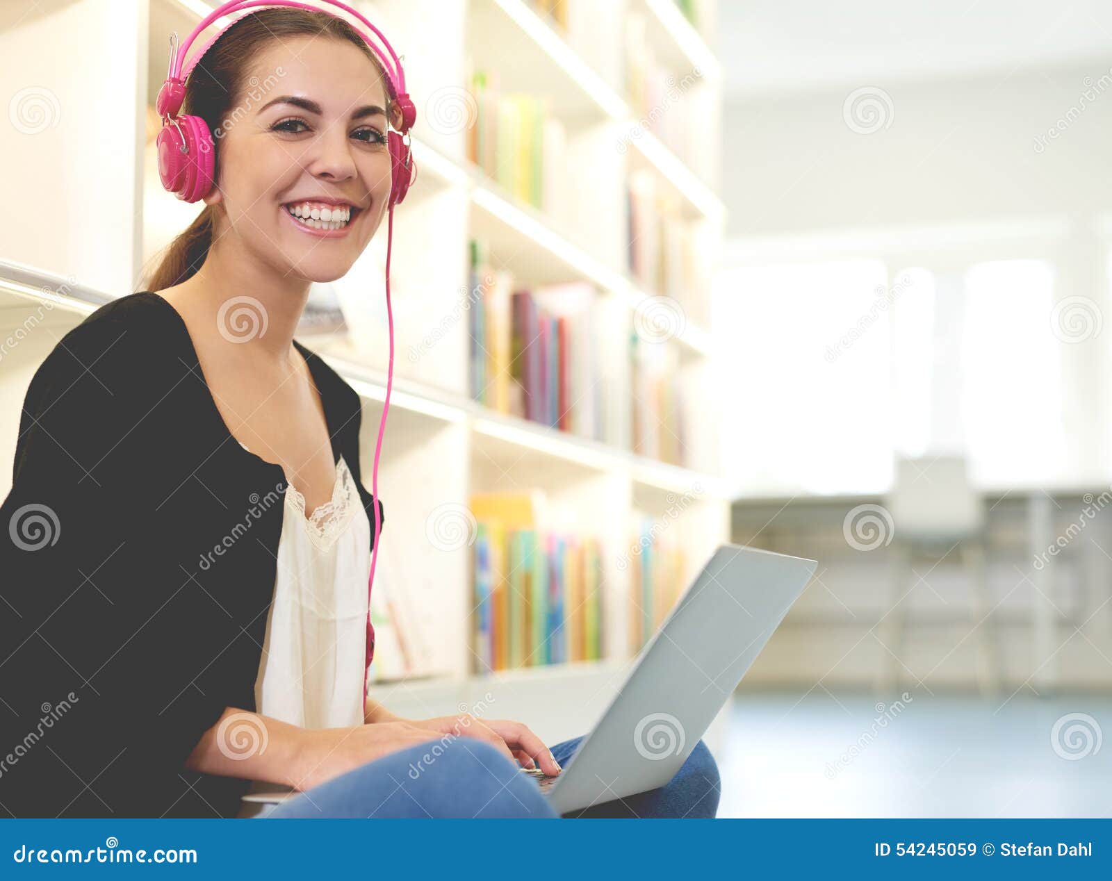 young woman listening to music as she studies