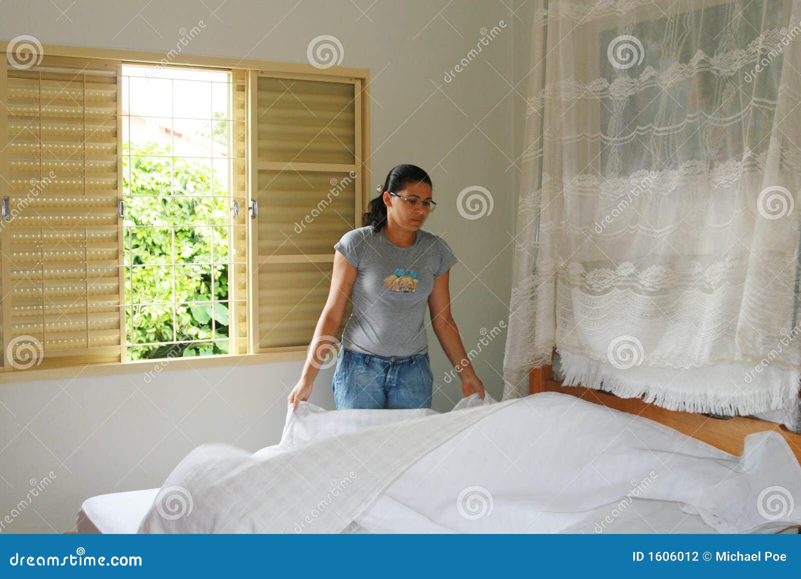 young woman making bed