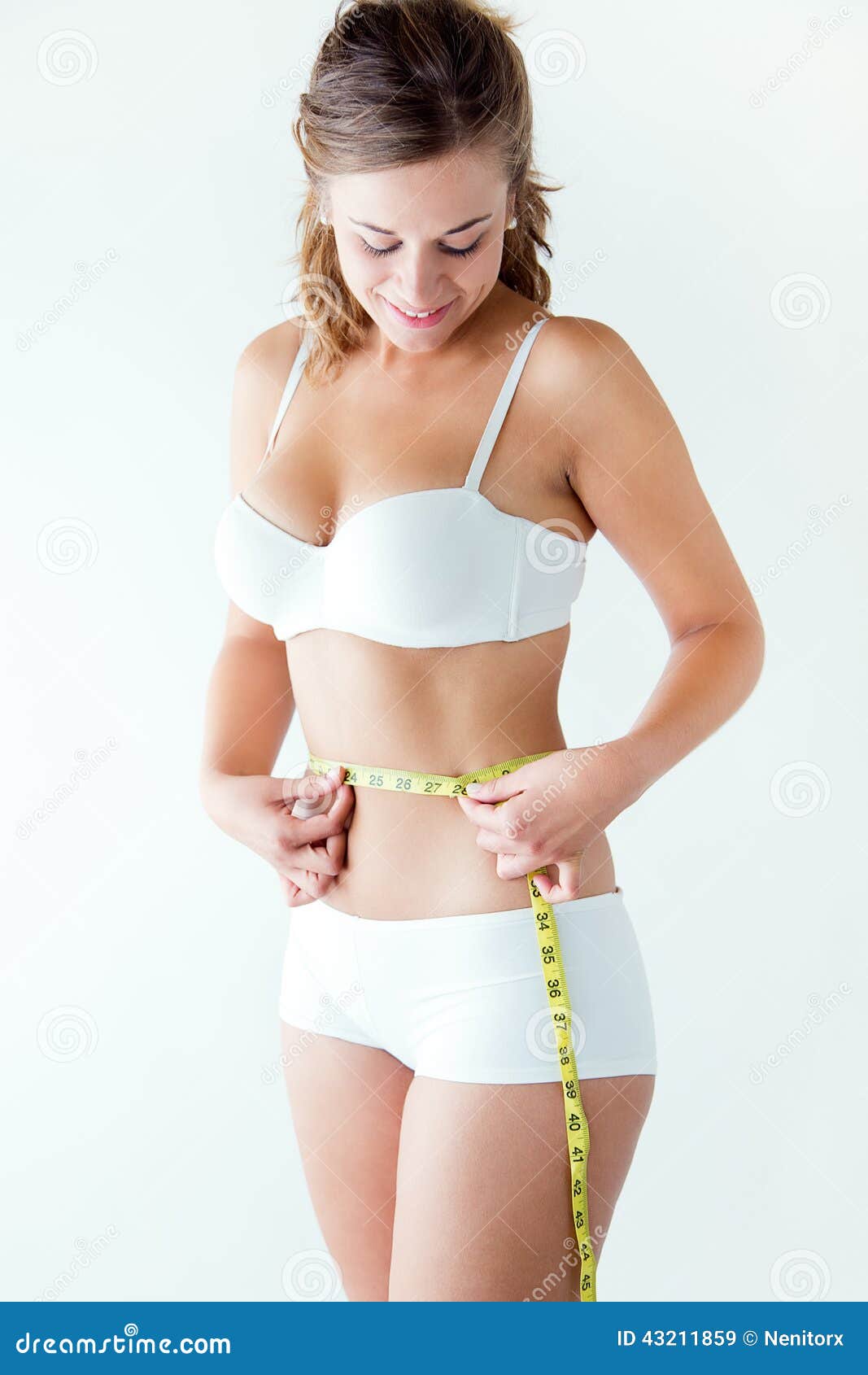 young woman measuring her waist by measure tape.