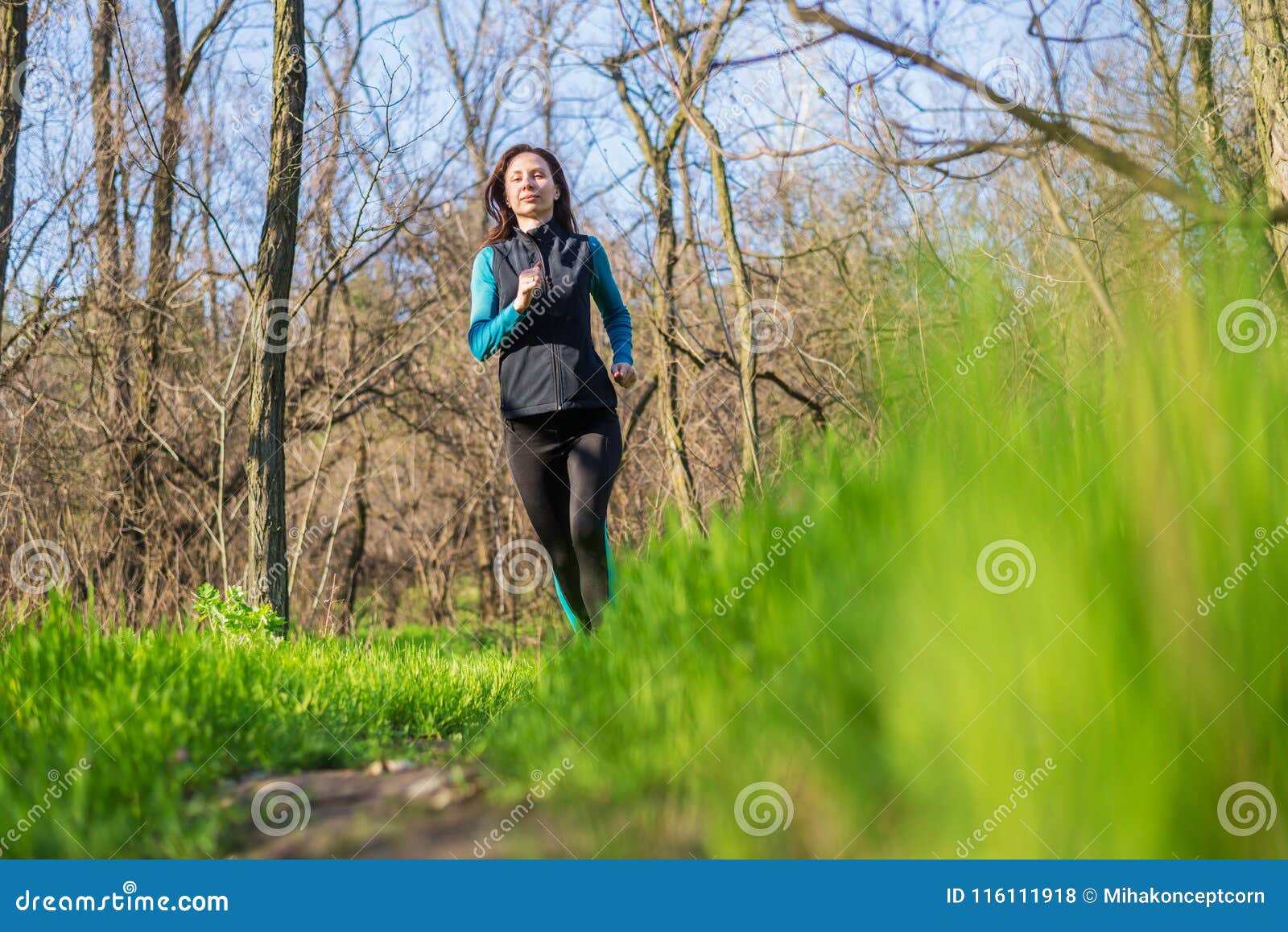 Young Woman on a Morning Run through the Spring Forest. Stock Photo ...