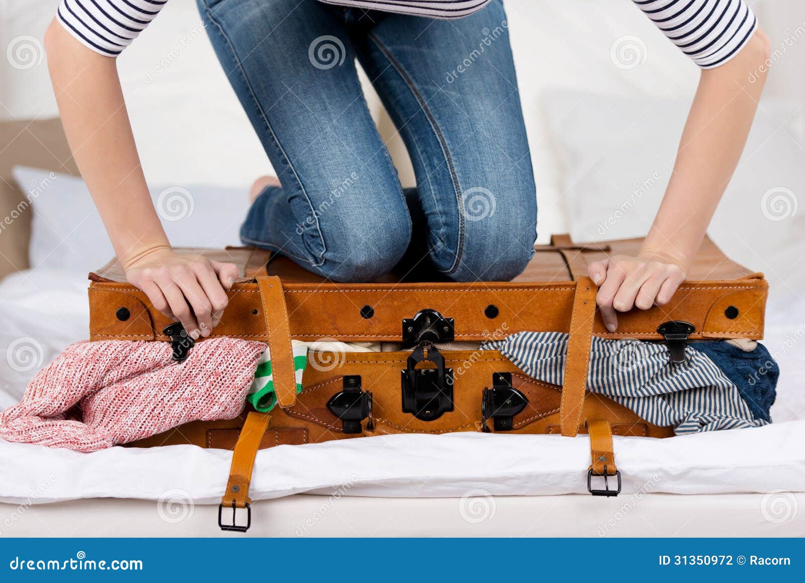 Young woman packing luggage in bedroom at home stock photo