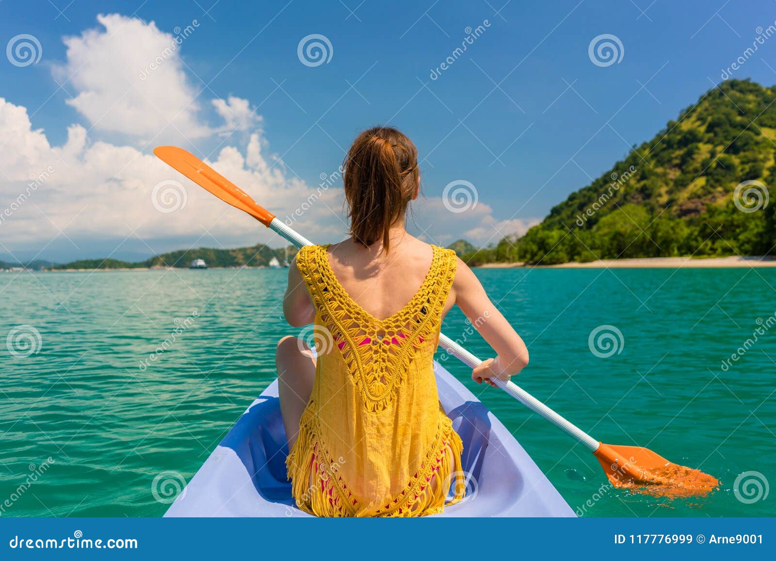 young woman paddling a canoe during vacation in flores island