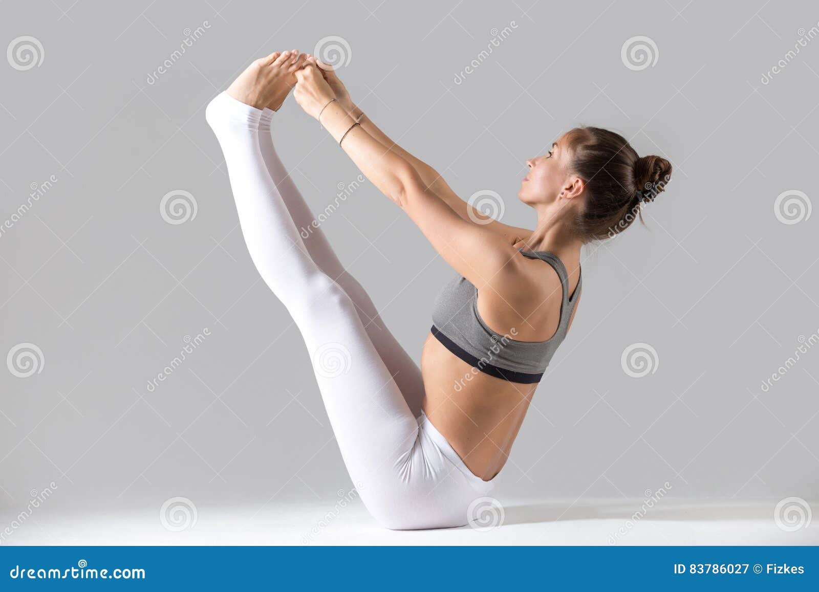 Woman doing boat yoga pose on the beach stock photo (238147