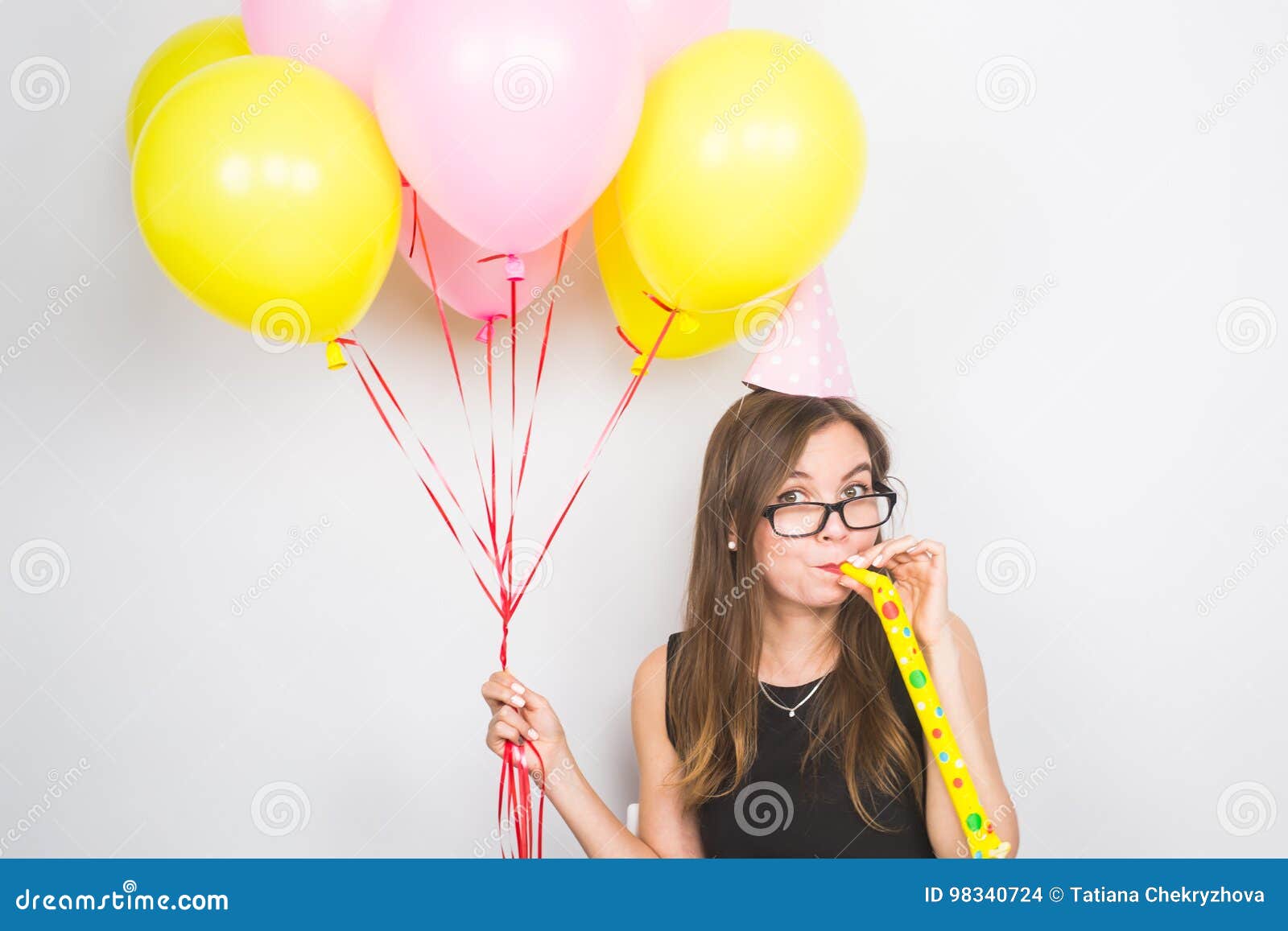 Young Woman with Party Hat with Noisemaker on a White Background Stock