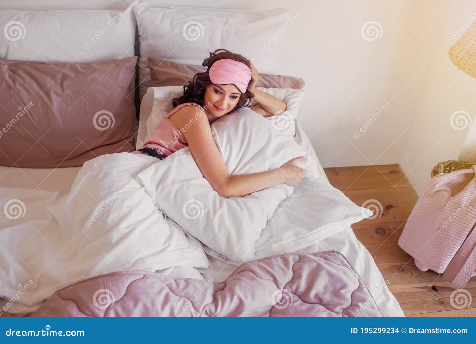 Young Woman in Pink Night Underwear and Mask To Sleep Near the