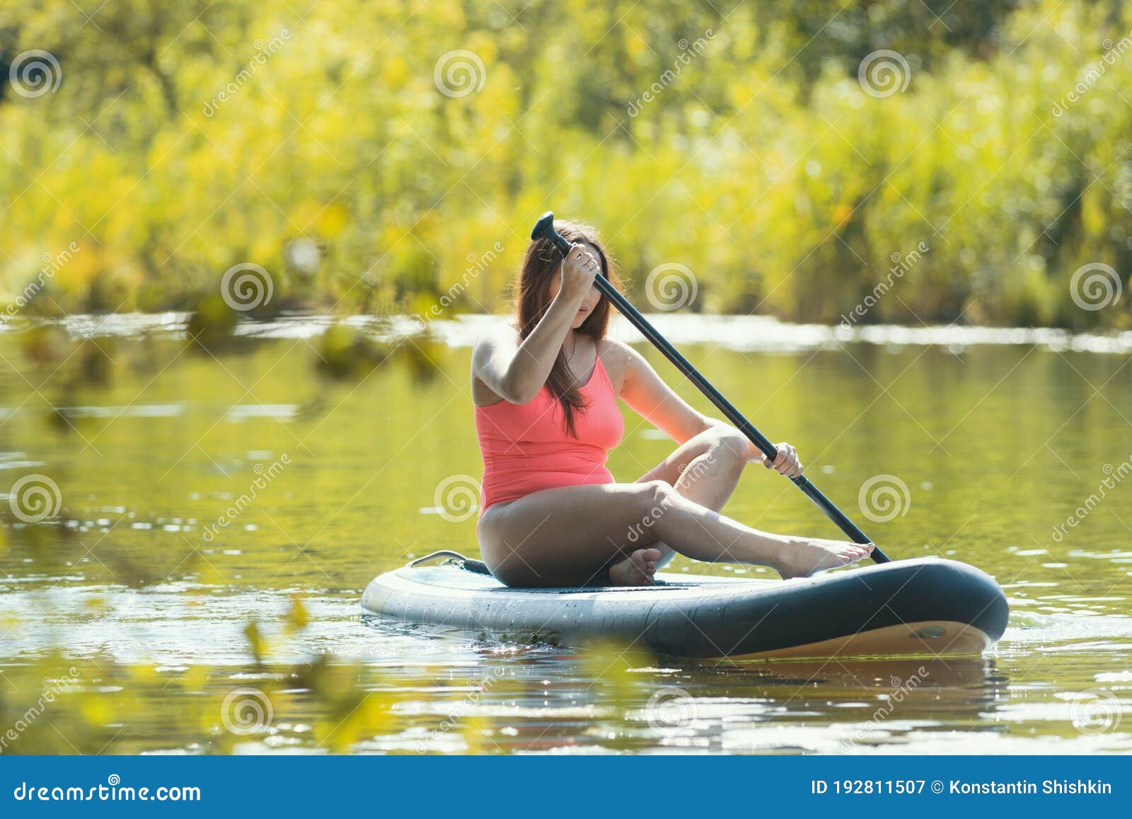 Young Woman in Pink Swimsuit Sailing on the Inflatable Boat with an Oar ...