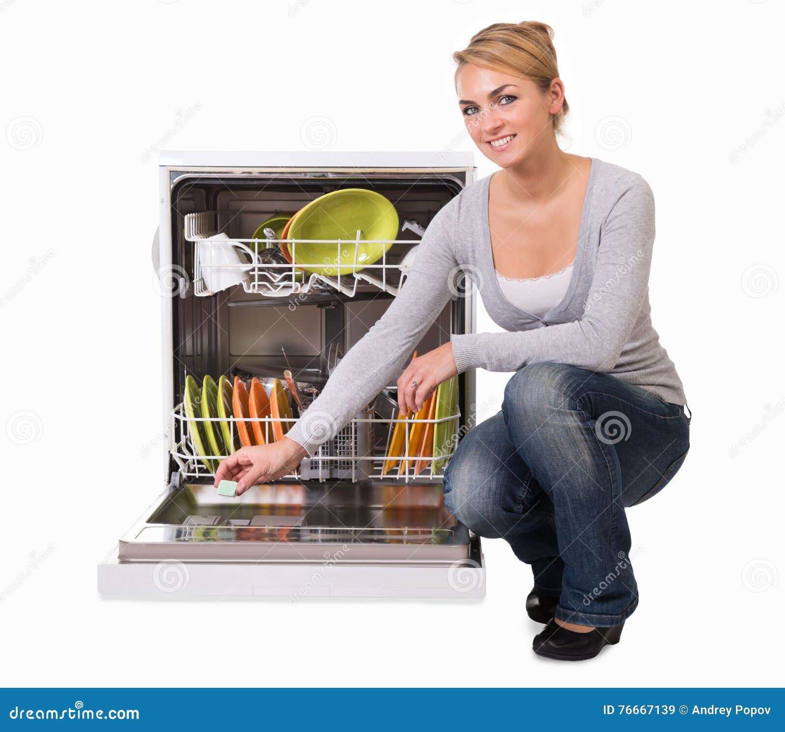 young woman placing soap in dishwasher