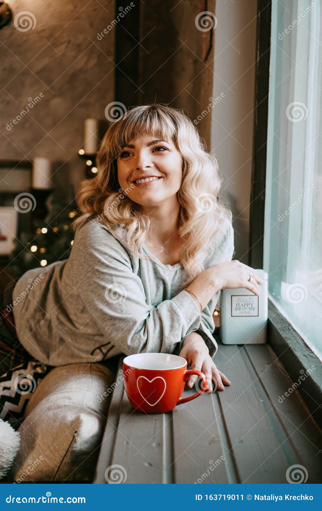 Young Woman with Cup of Tea in Christmas Cozy Interior. Make a Wish and ...