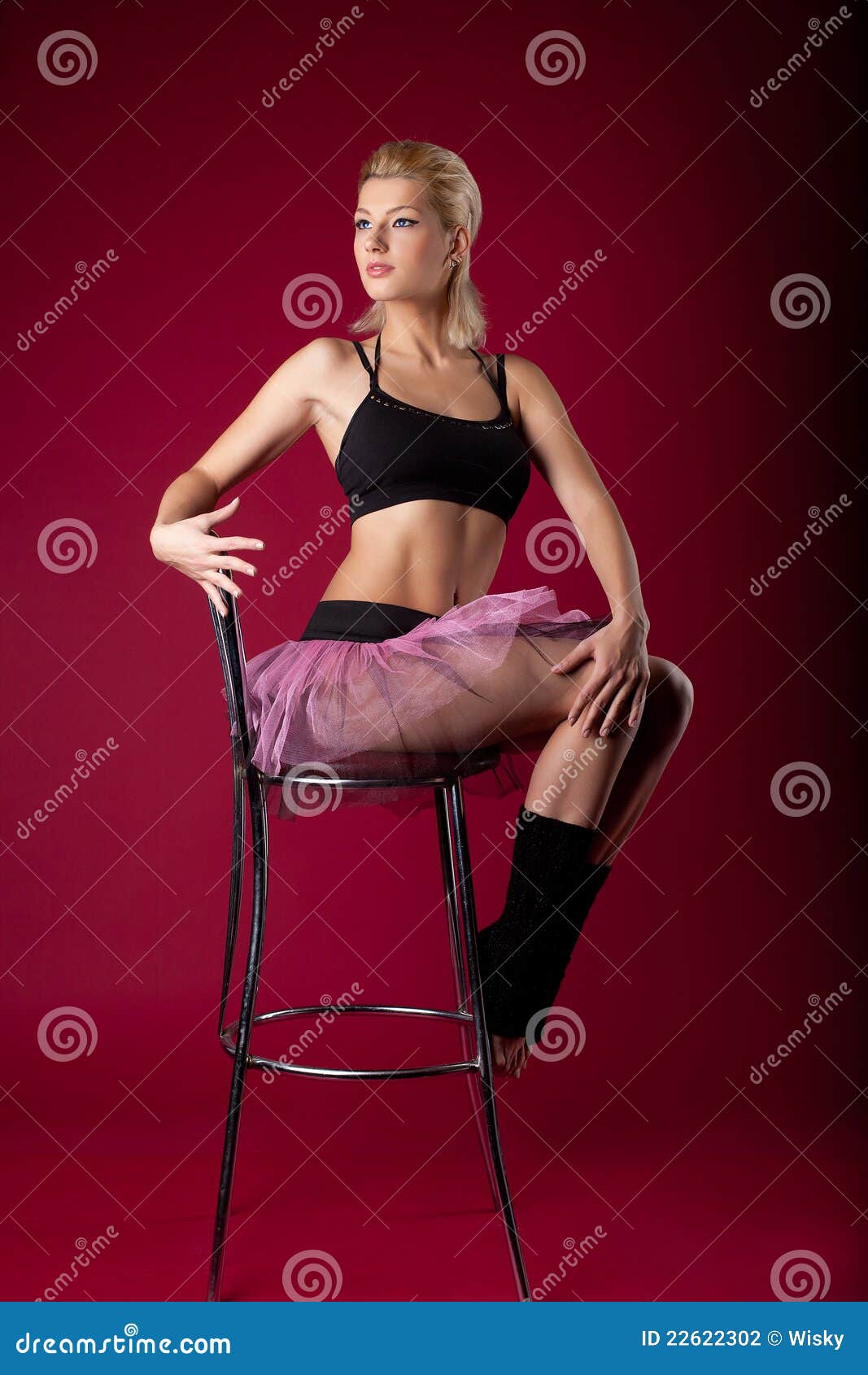 Young Woman Posing In Dance Sport Costume On Chair Stock Photo