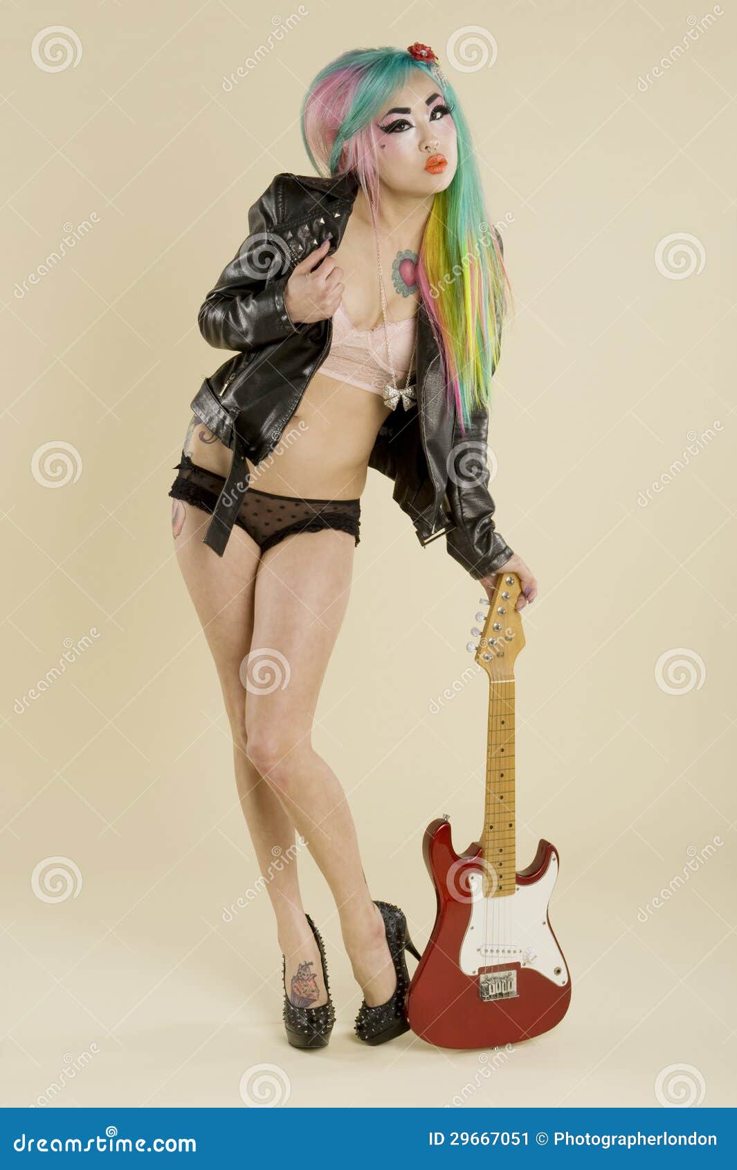 Young Woman Posing With Guitar Over Colored Background 