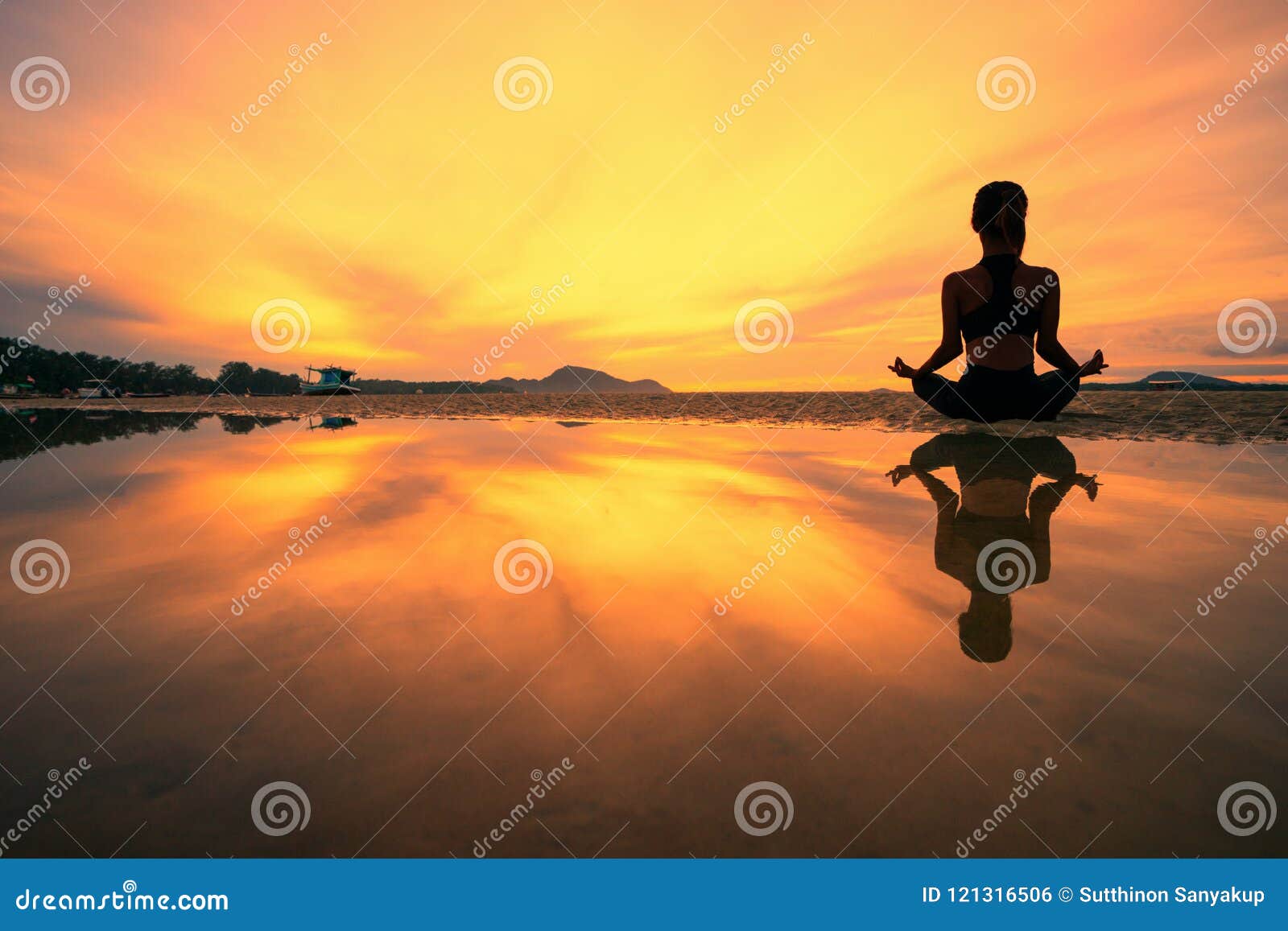 Young woman practicing yoga at beach