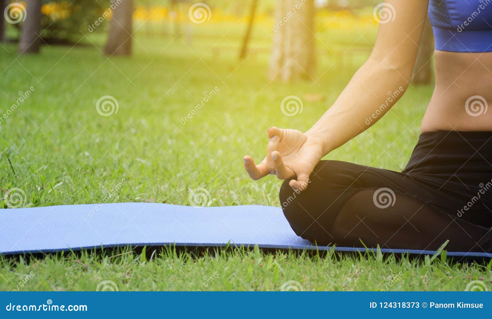 young woman practicing yoga in the park, stretching and flexibility, practiced for health and relaxation