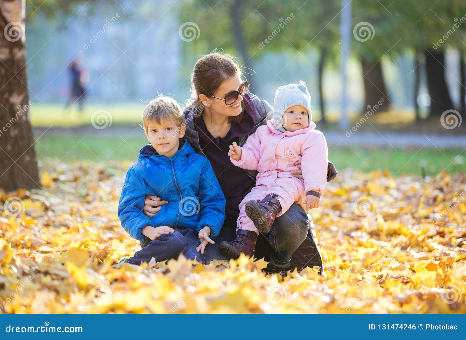 young woman with preschool son and baby daugther enjoying beautiful day