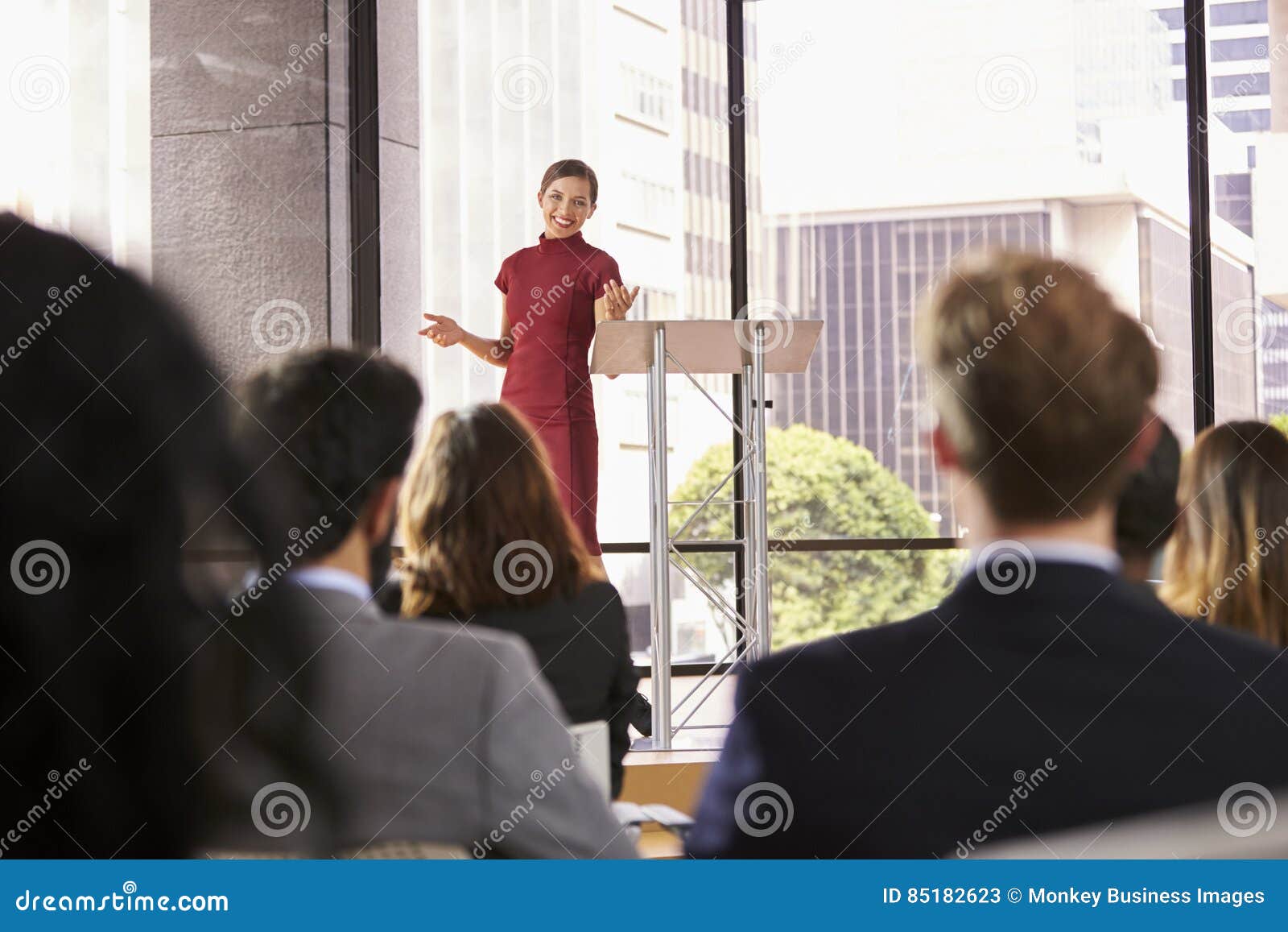 young woman presenting business seminar gestures to audience