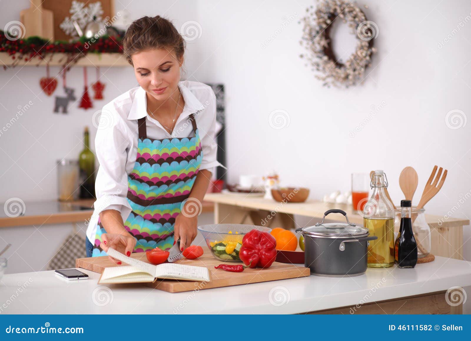 young woman reading cookbook in the kitchen,