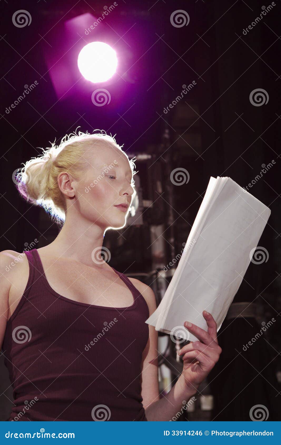 young woman reading script on stage