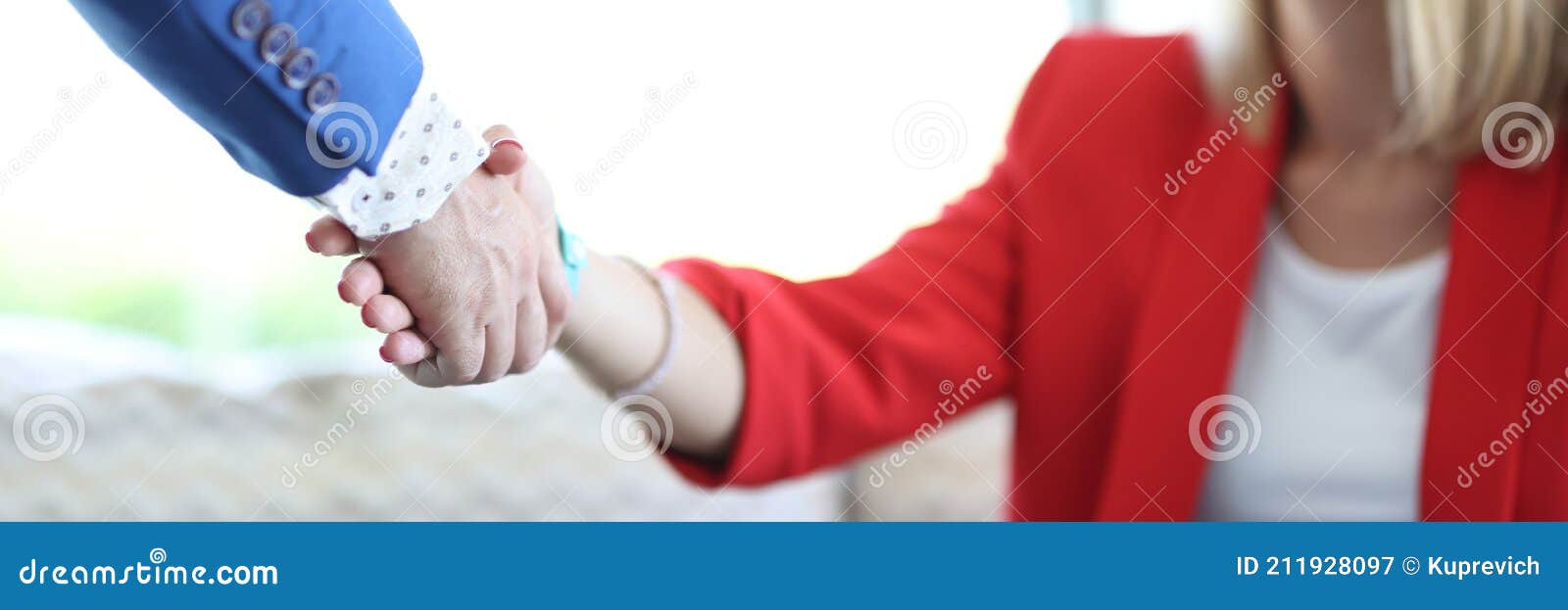 young woman in red jacket shakes man& x27;s hand closeup